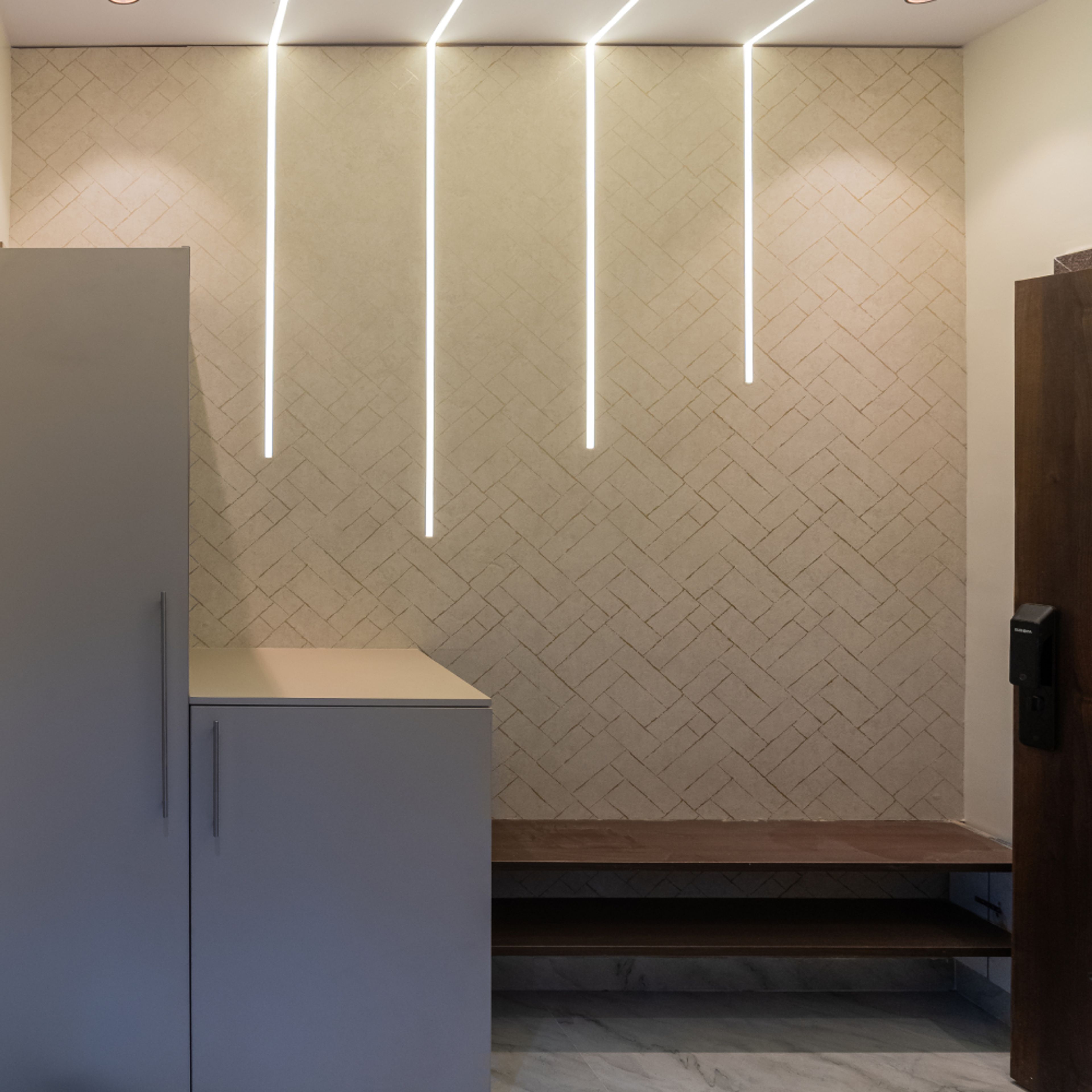 Foyer Design with Shoe Cabinets, wooden Seating Bench, Brick Pattern Wallpaper and Cove Lights