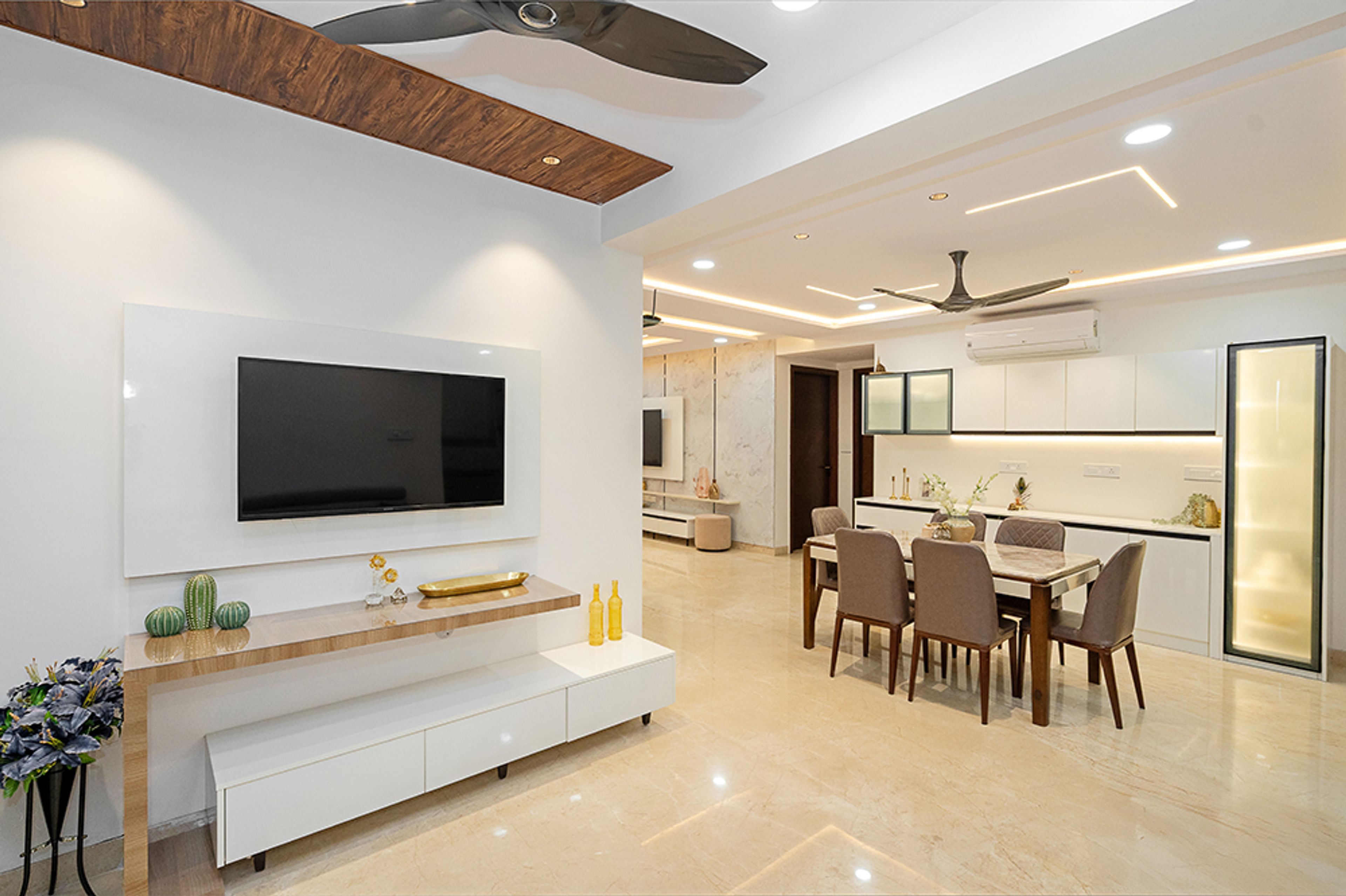 Living Cum Dining Room Design with White TV Unit and 6-Seater Dining Table
