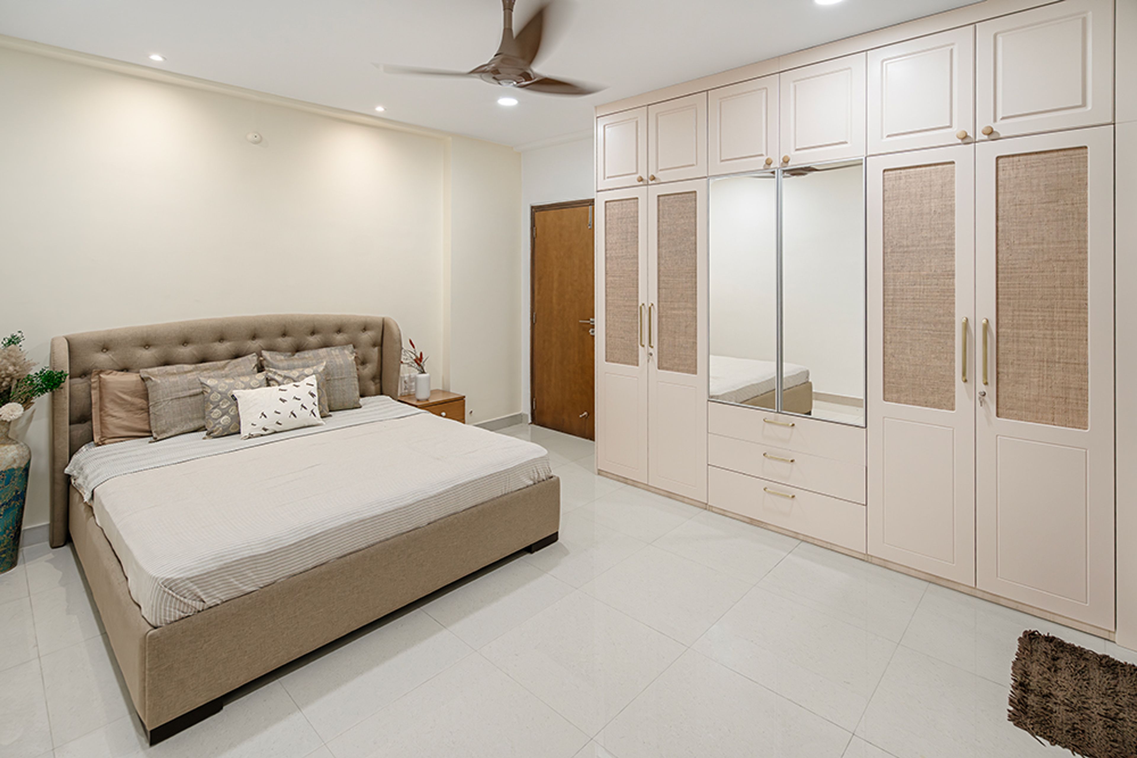 Bedroom Design with Brown Tufted Headboard Bed and 4-Door Swing Wardrobe with Attached Mirror