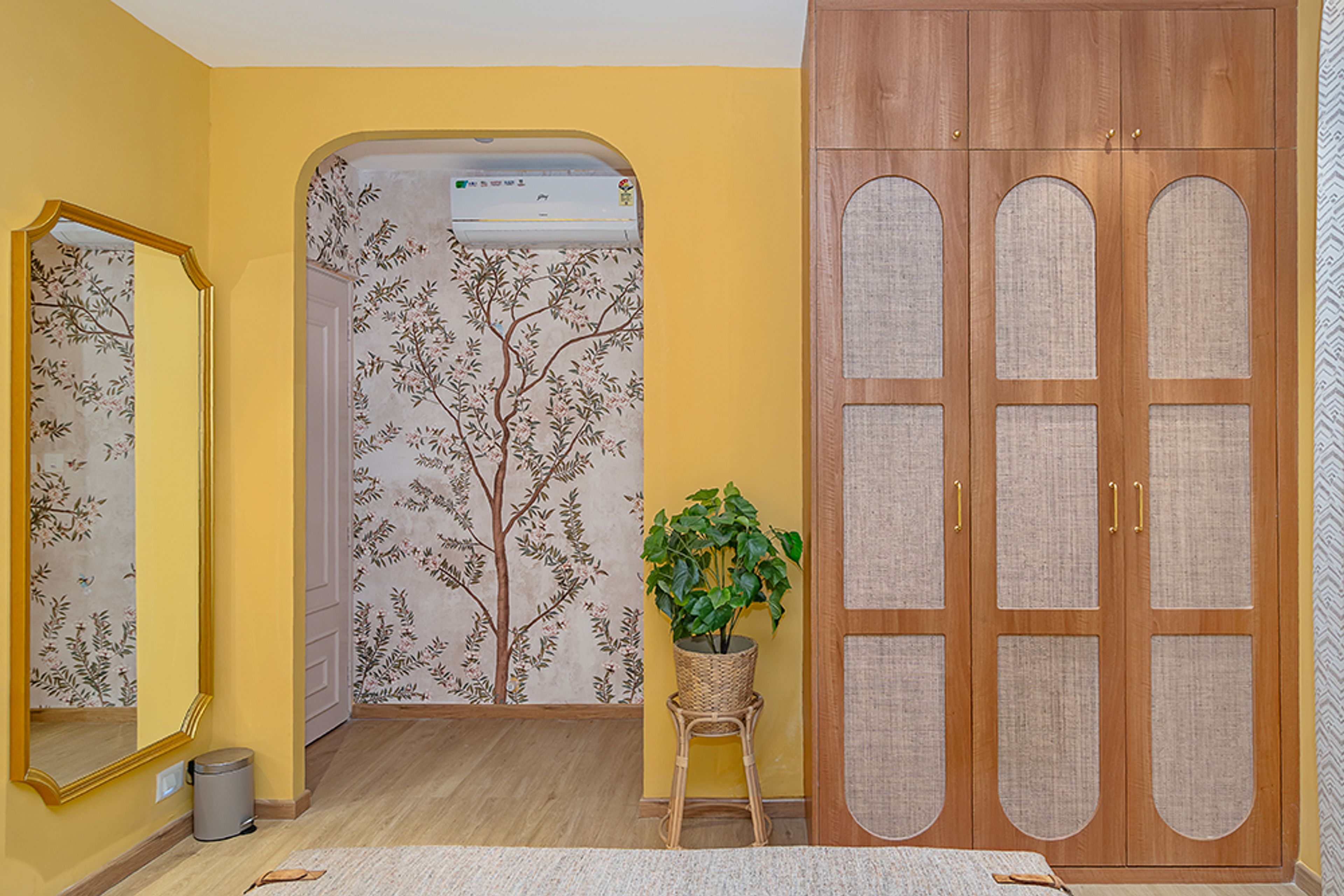 Bedroom Design with Wooden 3-Door Swing Wardrobe and Yellow Wall and Tree Themed Wallpaper