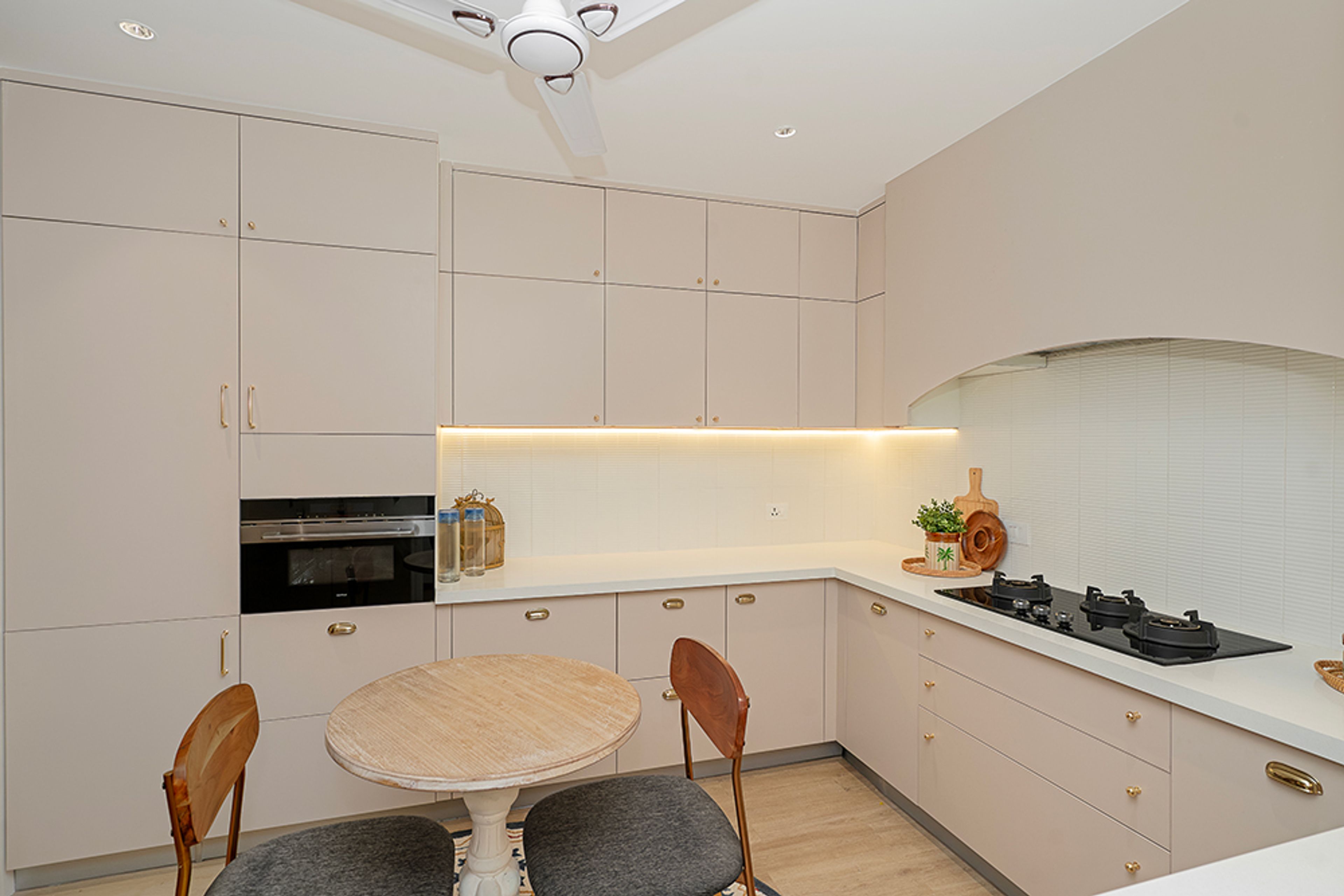 U-Shaped Kitchen Design with Cream Units and Wooden Round Dining Table