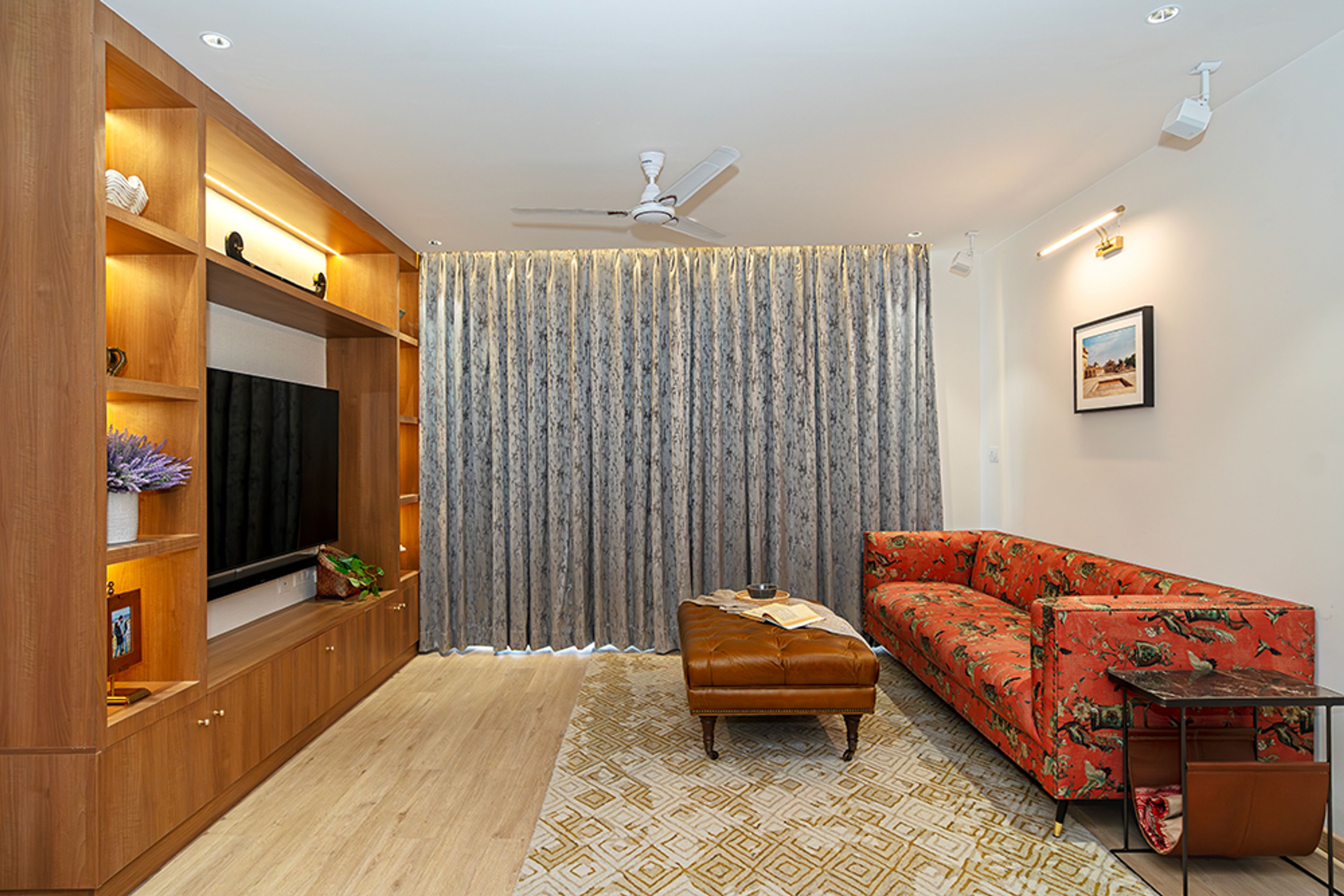 Living Room Design with Orange Printed Upholstered Sofa, Brown Leather Bench and TV Unit