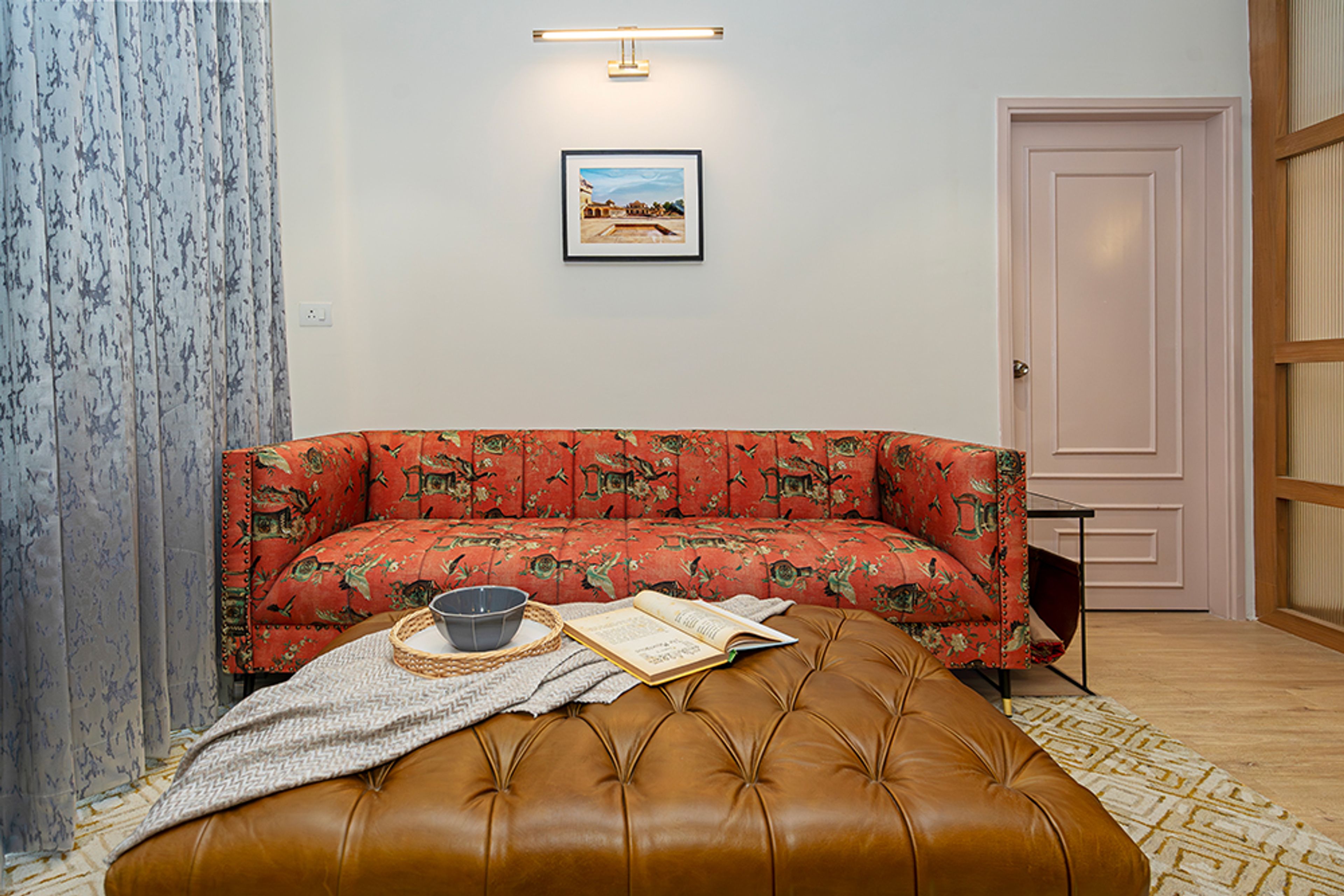 Living Room Design with Orange Printed Upholstered Sofa and Brown Leather Bench