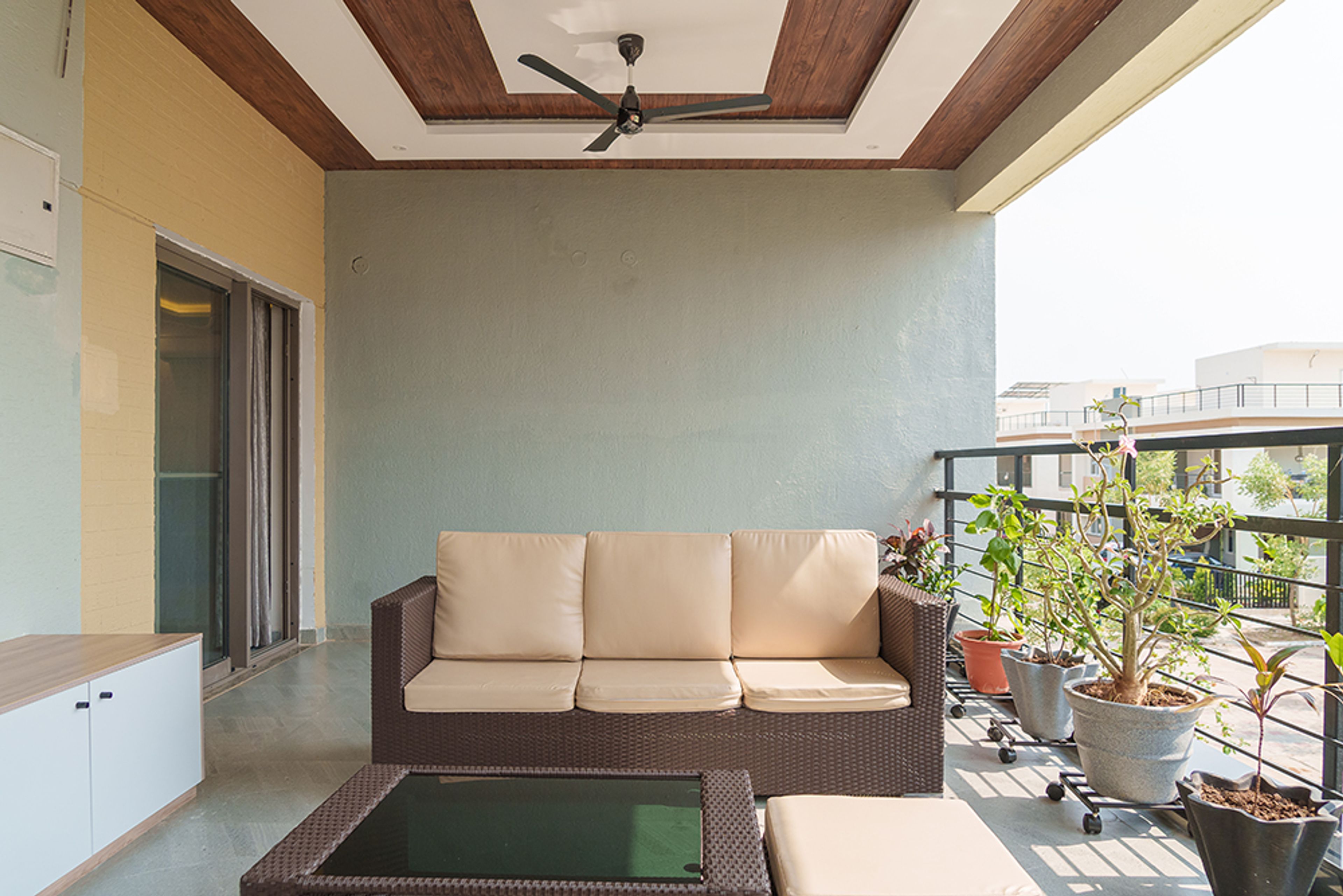 Balcony Design with Cane Sofa and Grey Wall