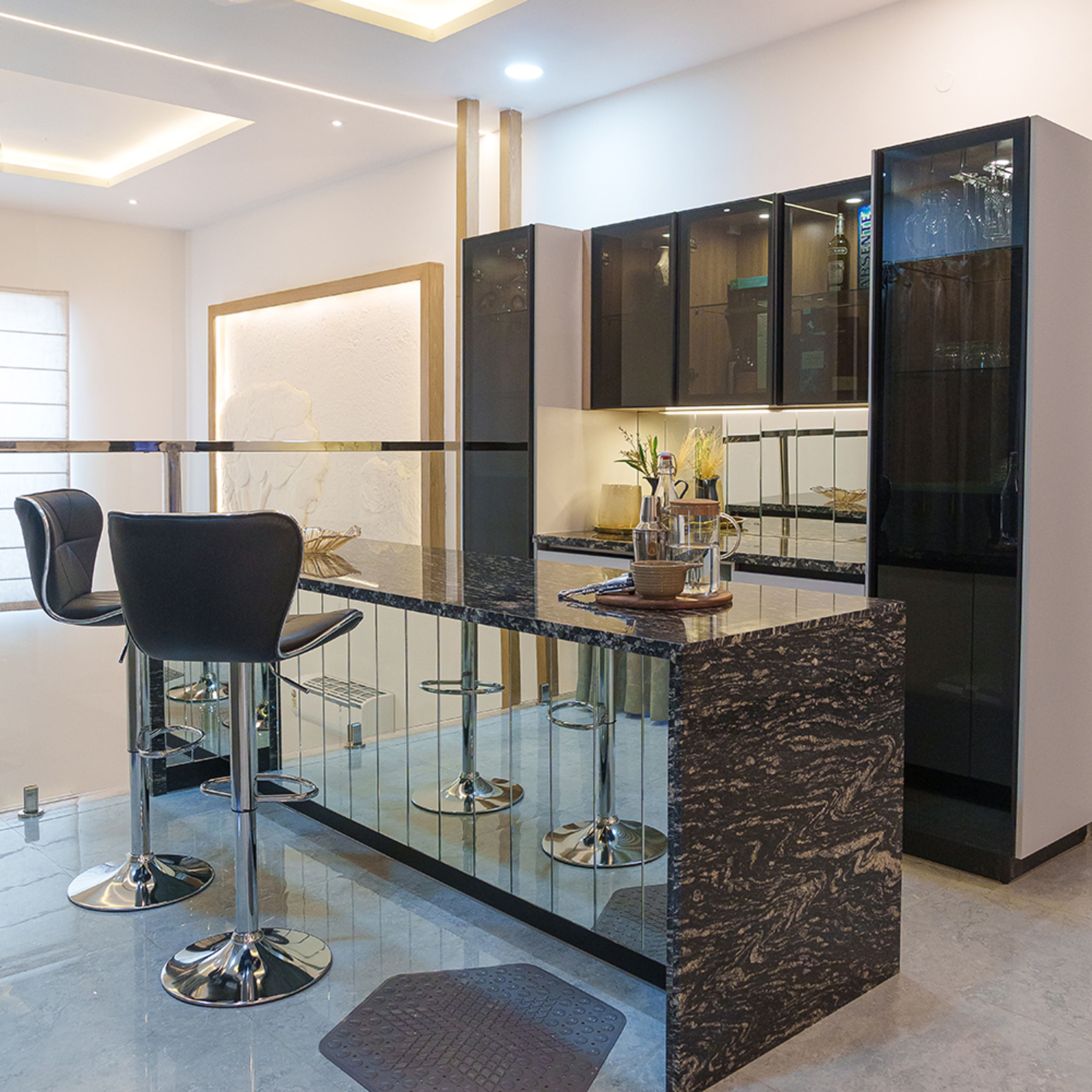 Home Bar Design with Mirrored Cabinetry, Black Marble Countertop, and Minimalist Accent Wall