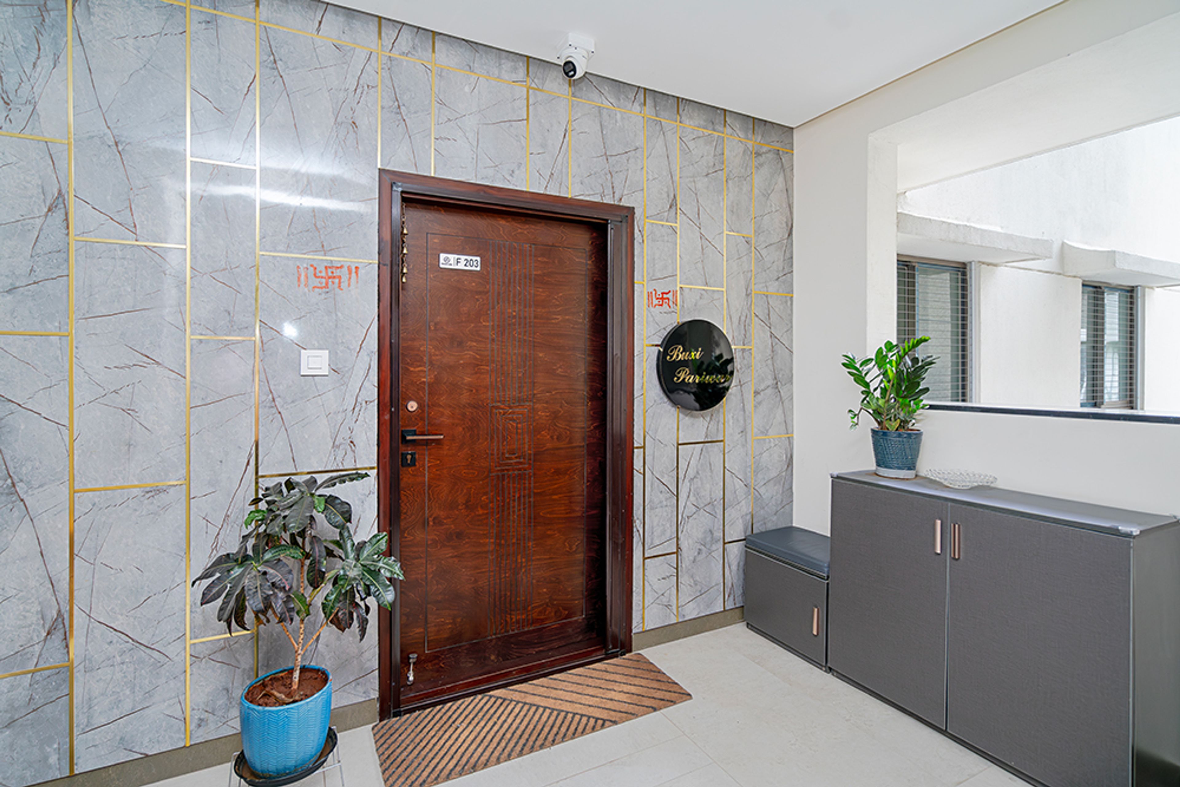 Foyer Design With Textured Grey Marble Walls with Gold Inlays and Grey Storage Cabinet