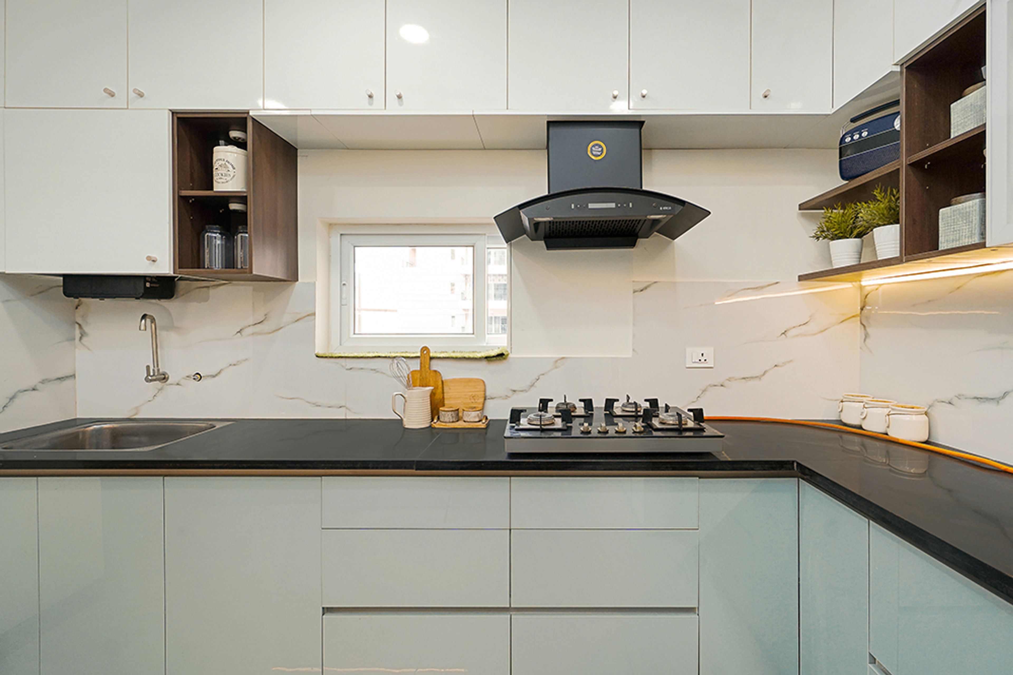 L-Shaped Kitchen Design with Marble Patterned Backsplash Tile and Chimney