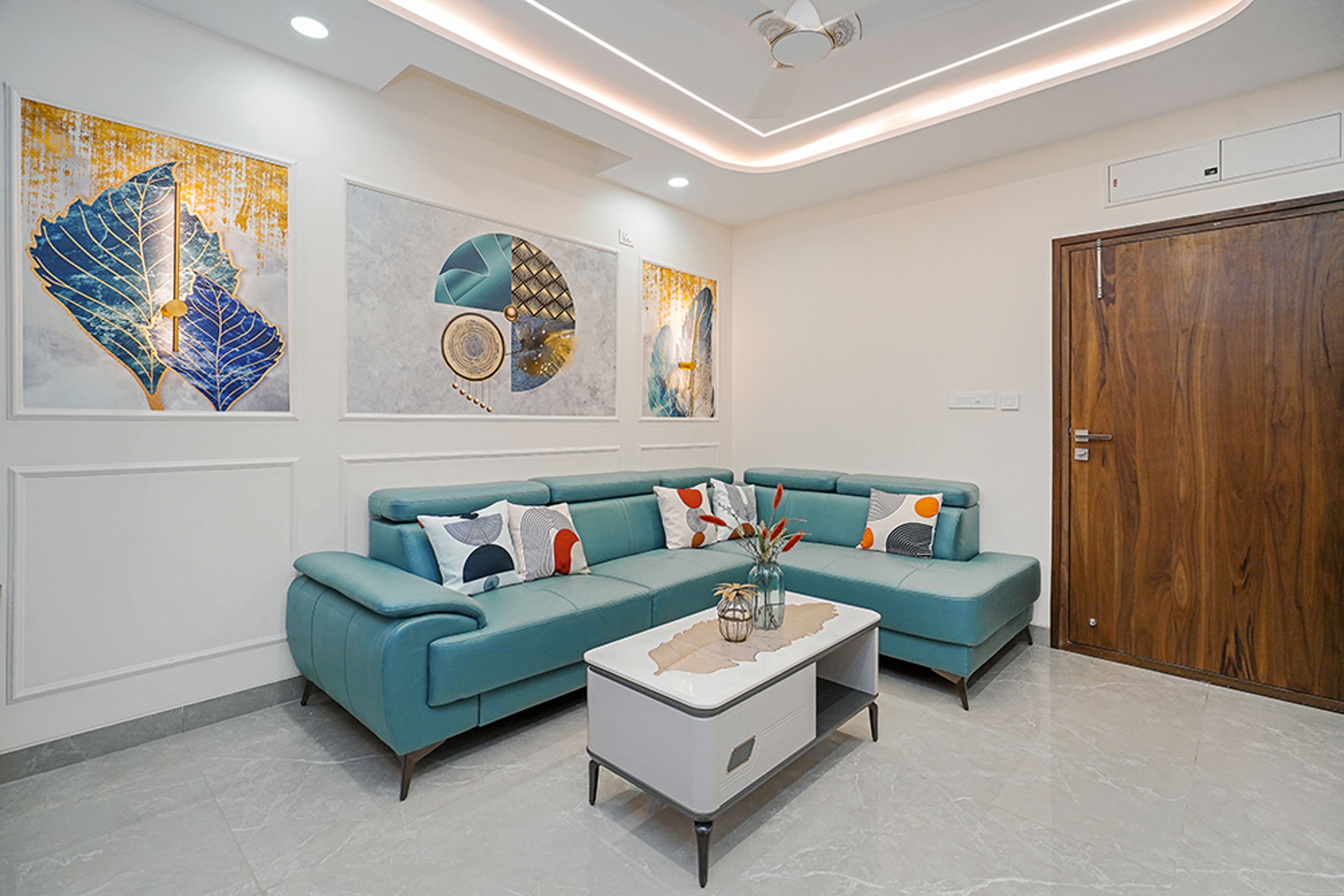 Living Room Design with Blue L-Shaped Sofa, Abstract Wall Art and White Center Table