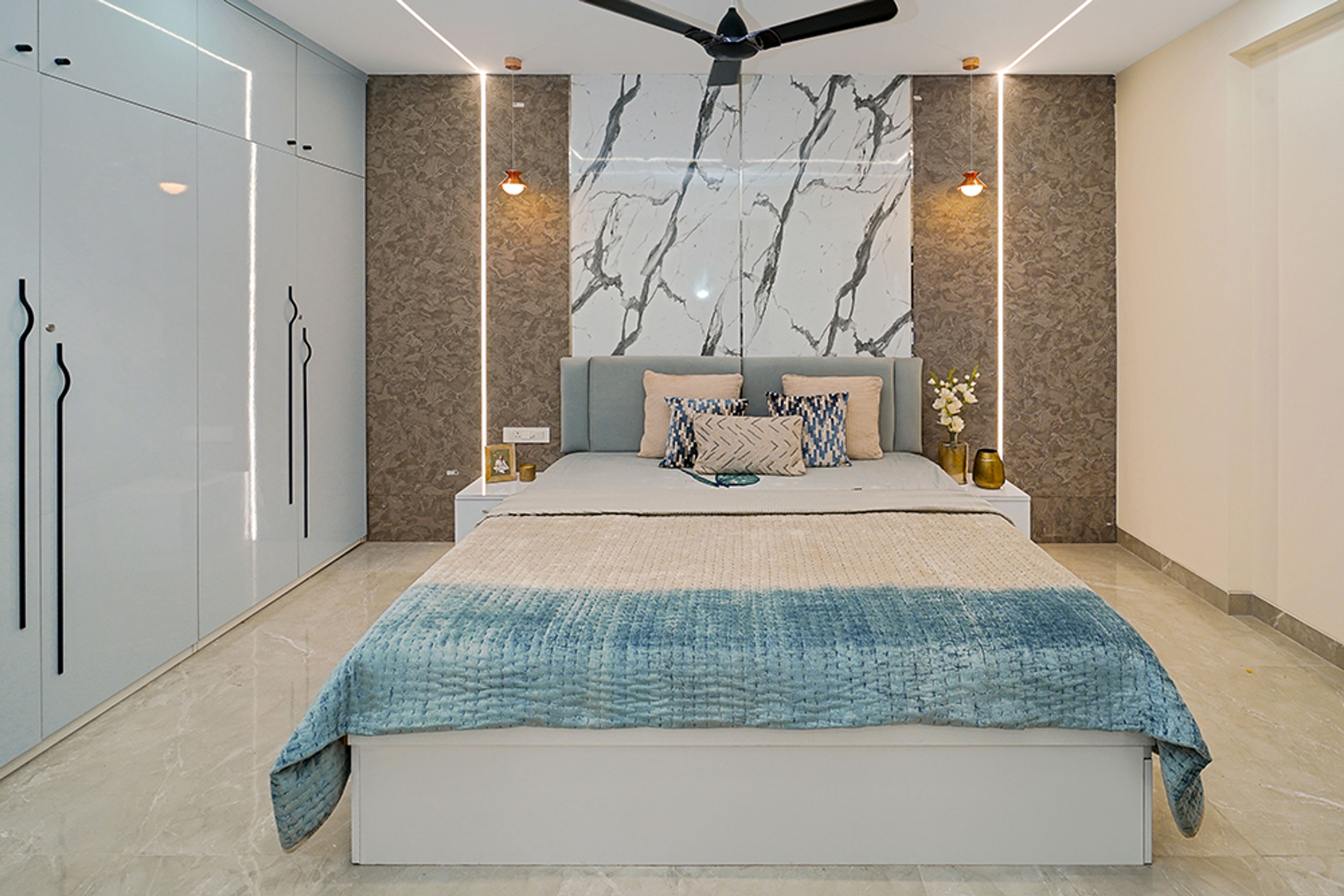 Bedroom Design with 4-Door Light Blue Swing Wardrobe and Marble Patterned Accent Wall