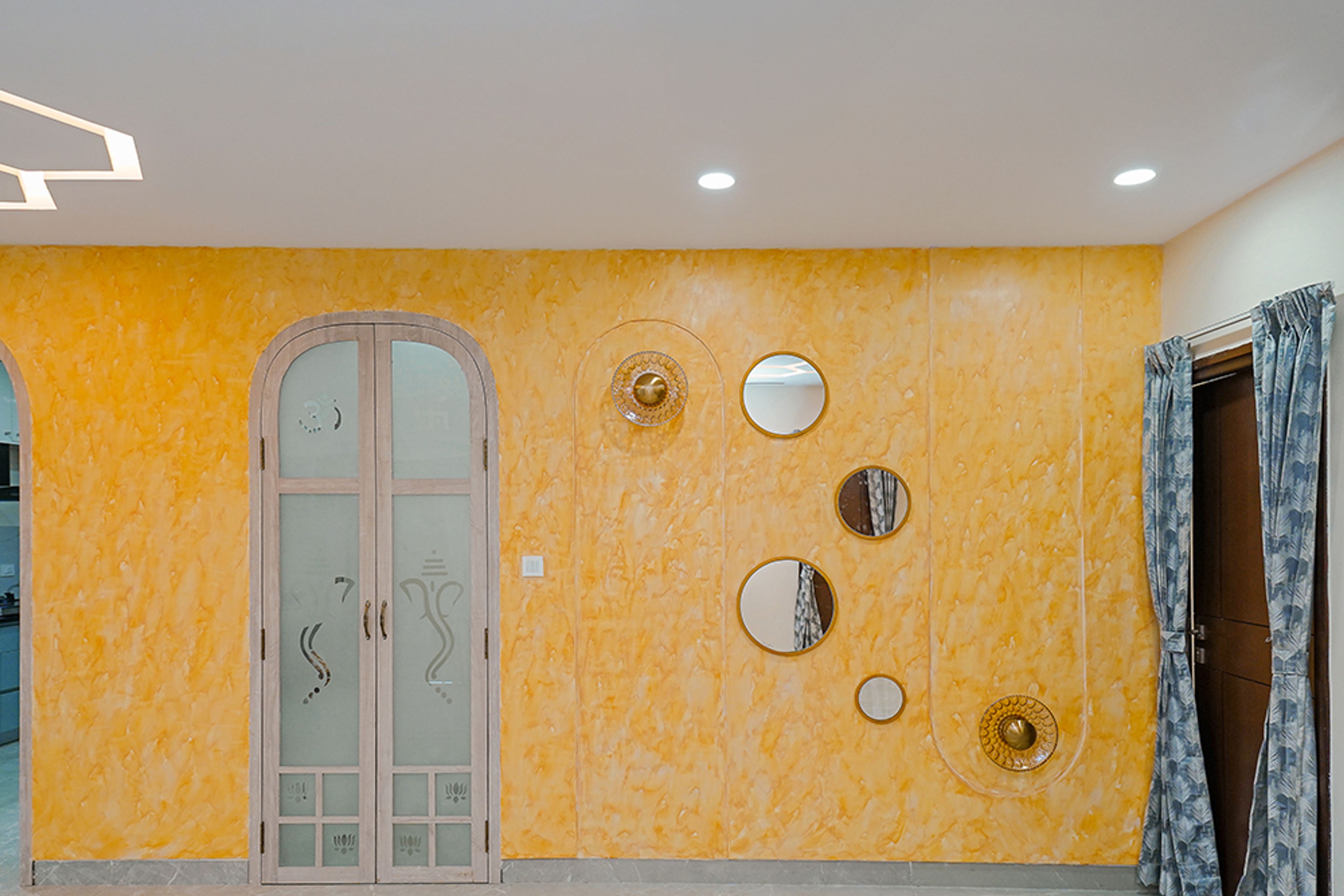 Pooja Unit Design with Closed Frosted Door with Ganesha Symbol and Yellow Textured Wall