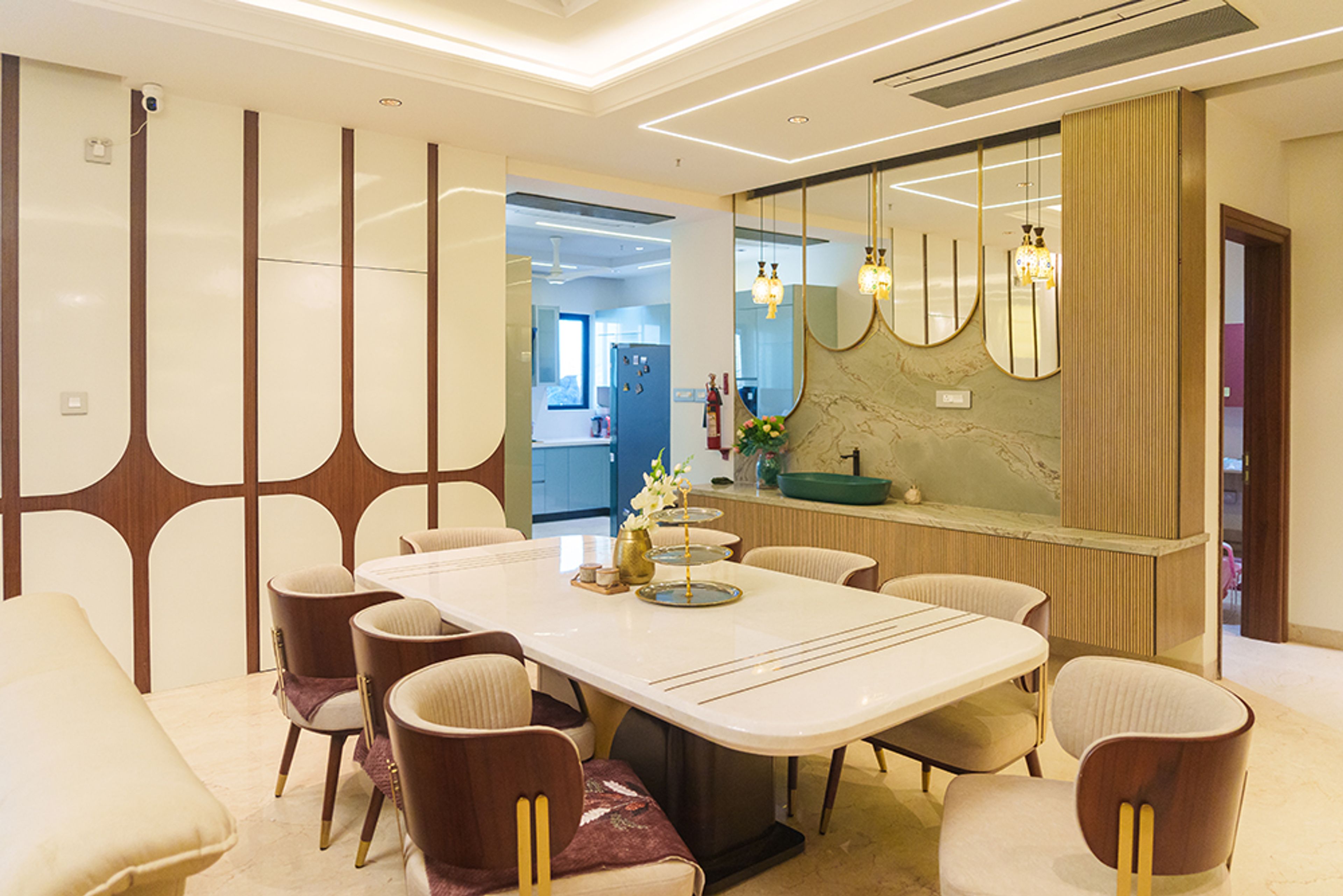 Living and Dining Room Design with Geometric Wood Accent Wall, Marble Dining Table and 8 Beige Chairs