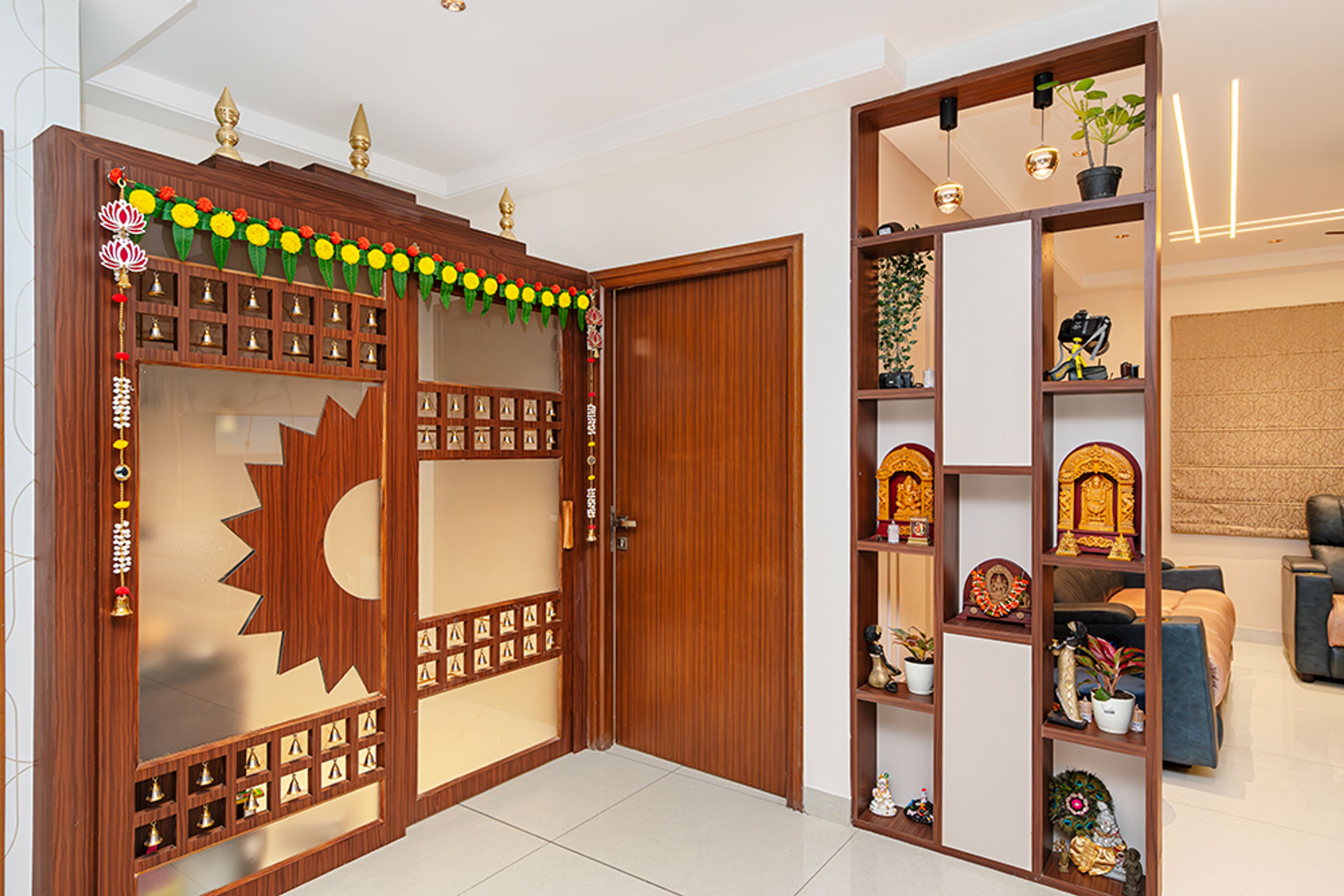 Foyer Design with Ornate Wooden Door, Decorative Partition Niche and Pooja Bells
