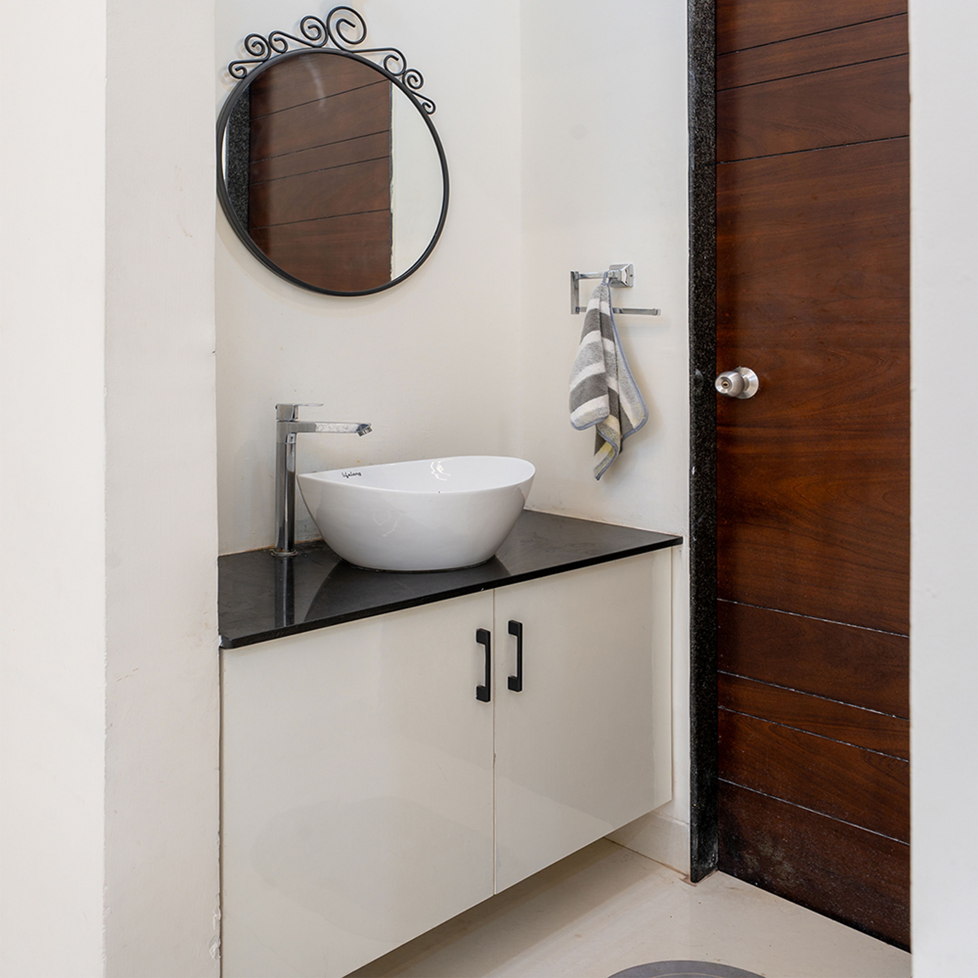 Sink Design with Round Mirror  and White Cabinets