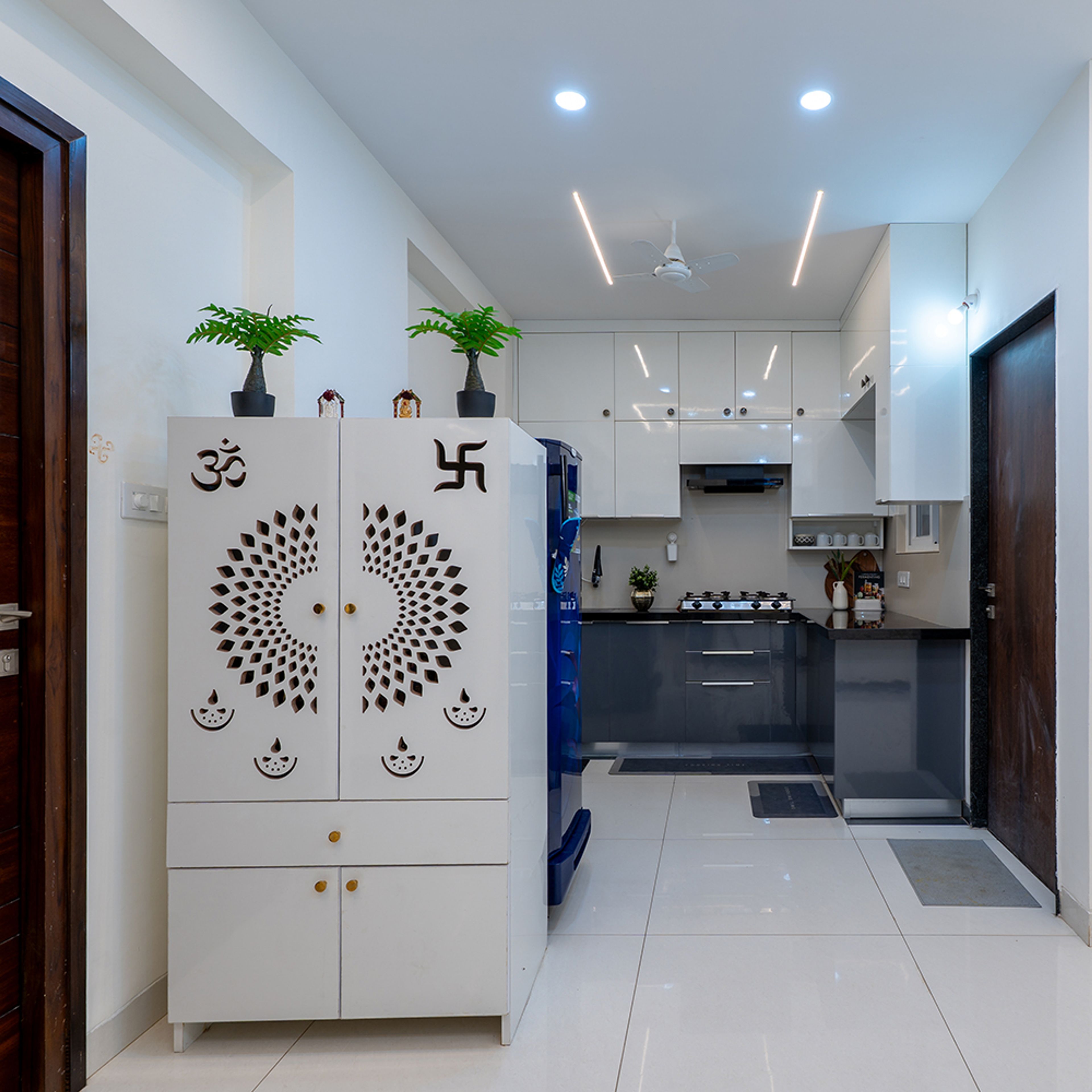 L-Shaped Kitchen Design with White and Grey Cabinets and White Pooja Unit