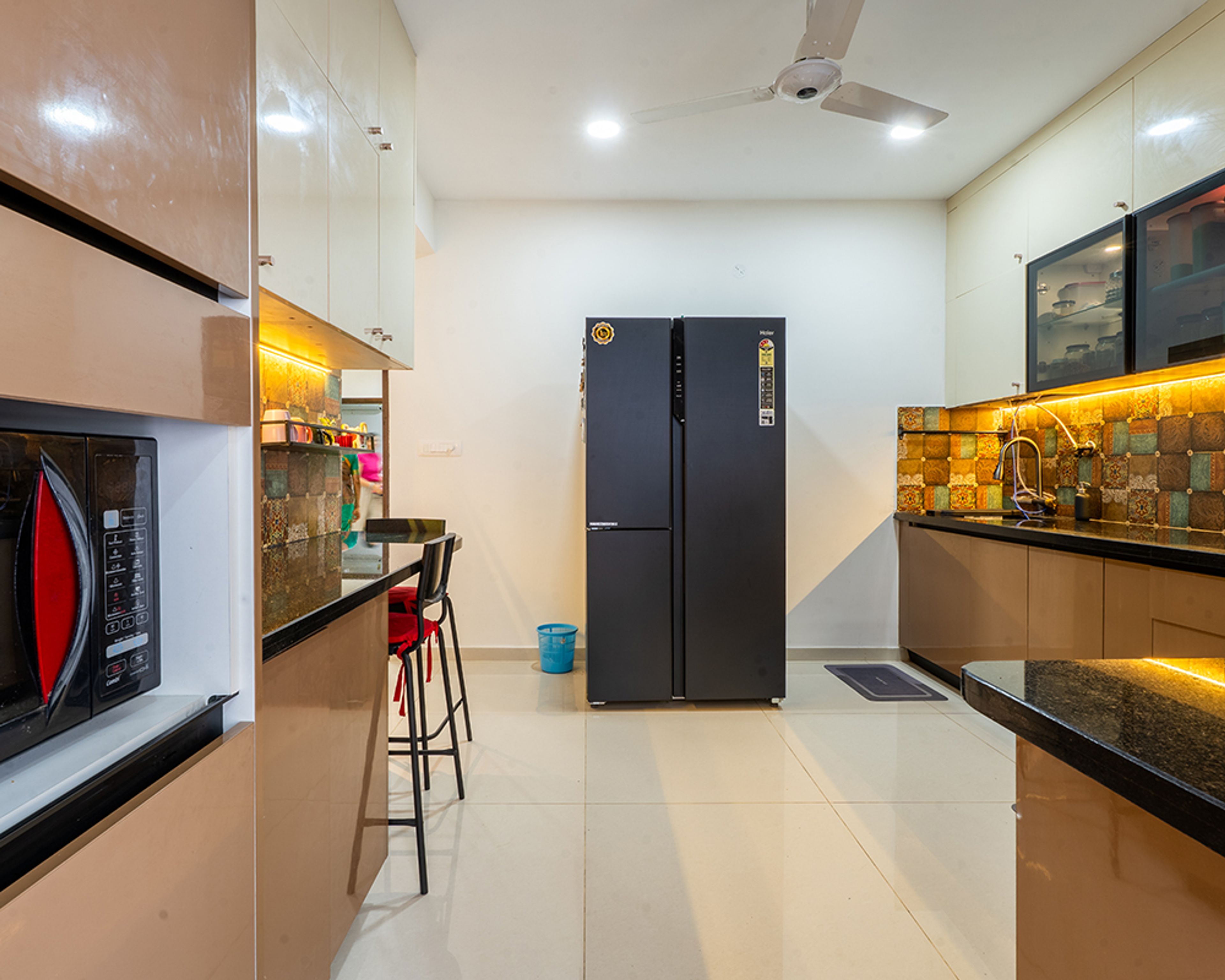 L-Shaped Kitchen Design with Brown Cabinets and Black Countertop