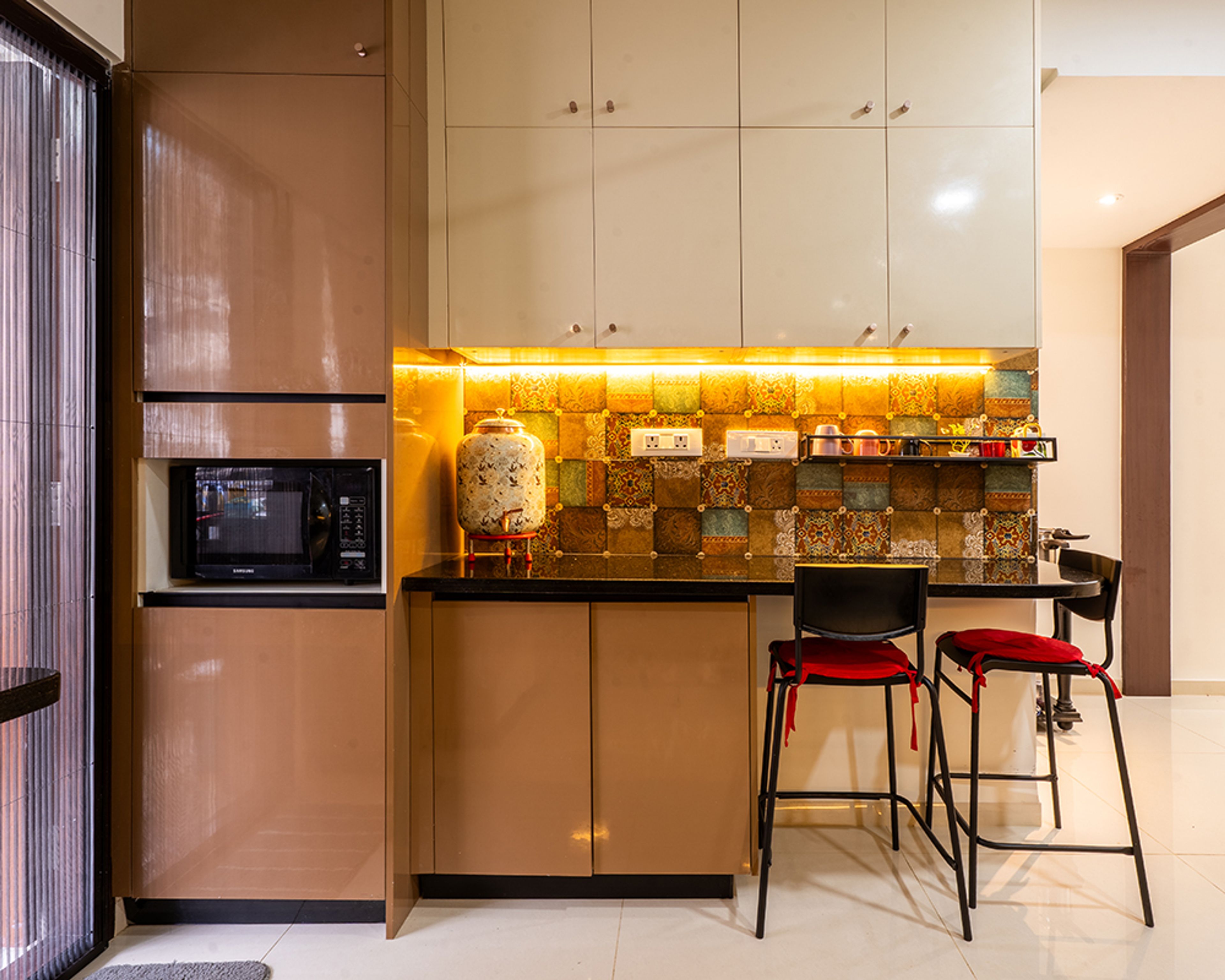L-Shaped Kitchen Design with Brown Cabinets, Patterned Tiles, and Black Countertop