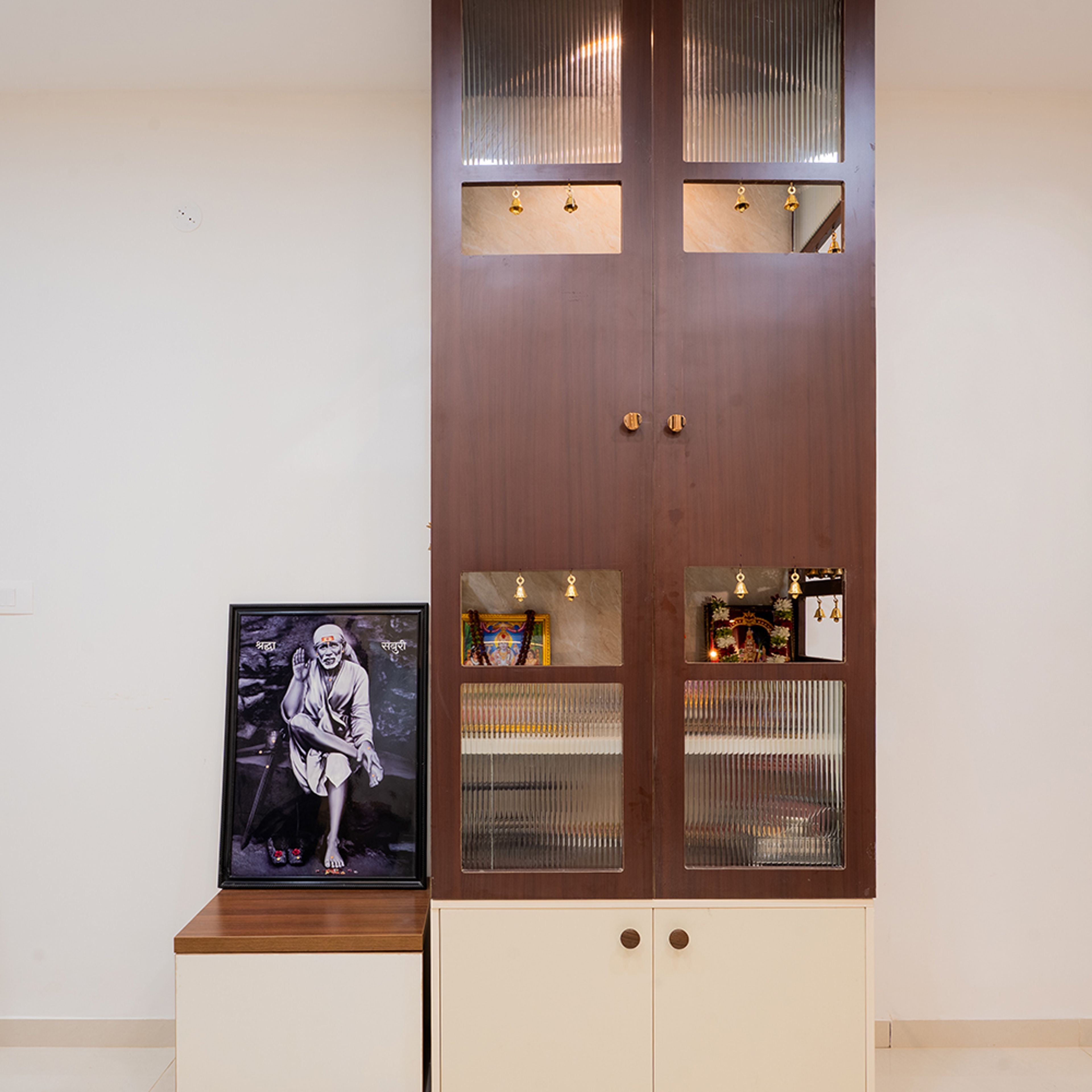 Pooja Room Design with Tall Wooden Cabinet and Glass Panels
