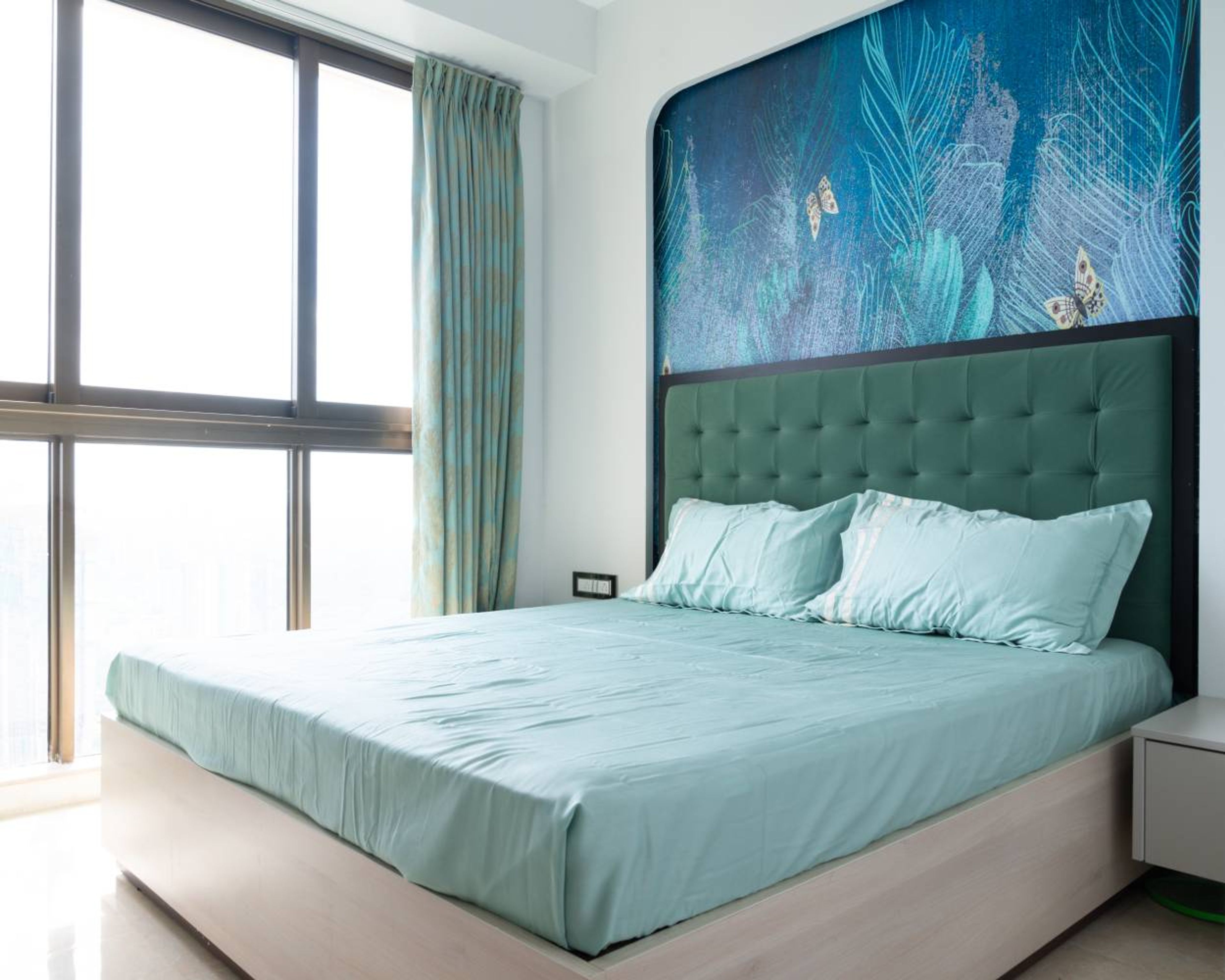 Master Bedroom Design with Queen Bed with Tufted Headboard and Feather and Butterfly Themed Blue Wall