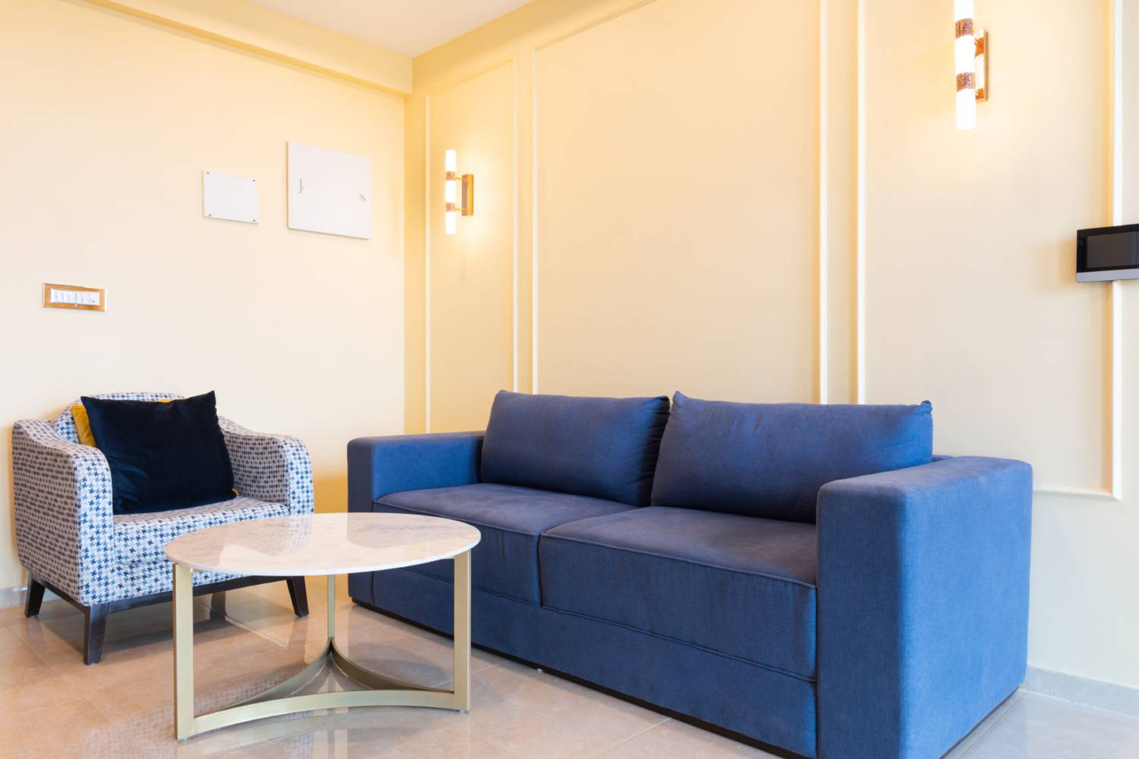 Living Room Design with Blue 2-Seater Sofa, Blue and White Upholstered Accent Chair and Cream Wall with Trims