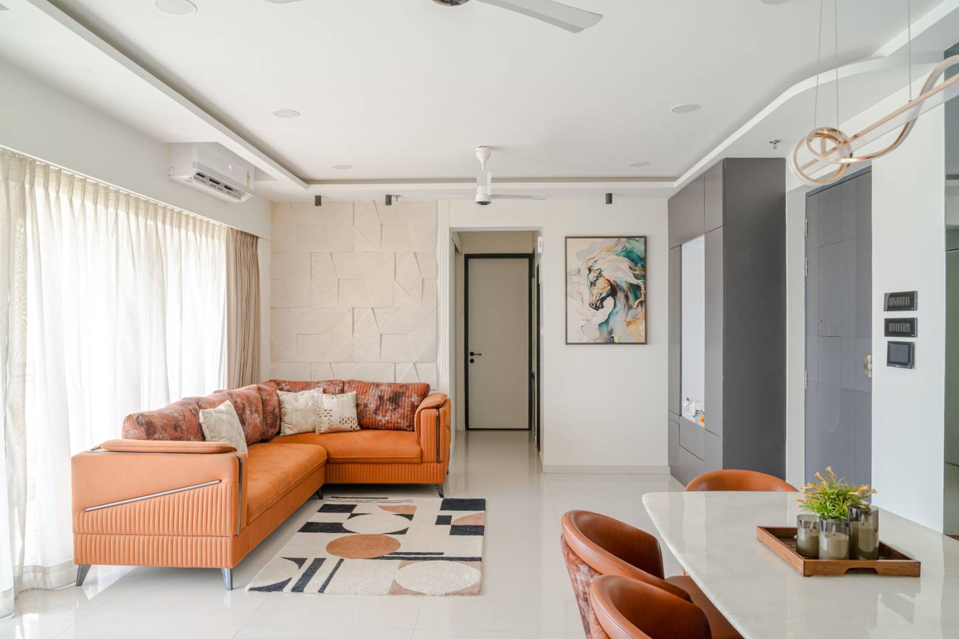 Living-cum-dining room with orange L-shaped sofa