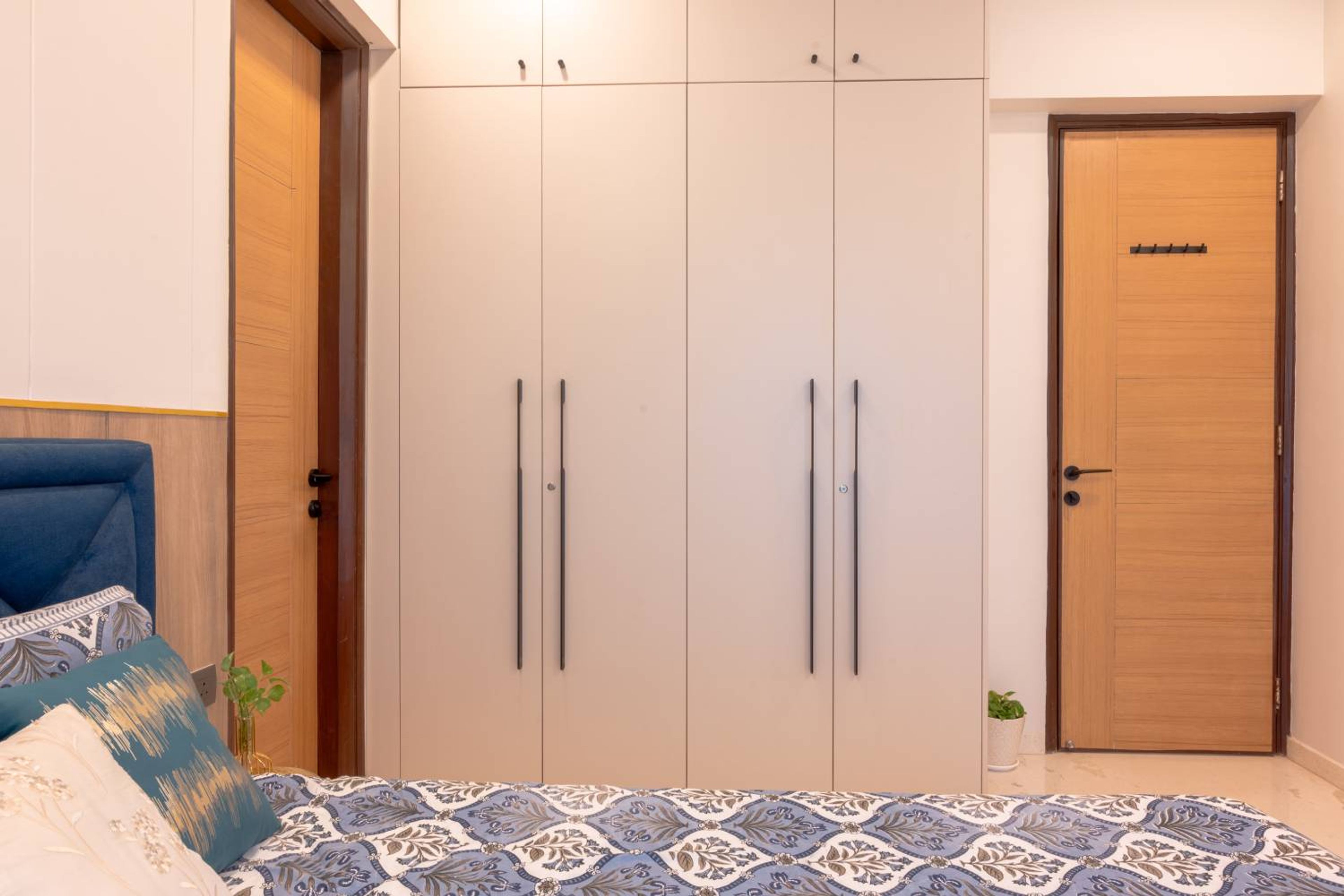 Master Bedroom Design with 4-Door Beige Swing Wardrobe