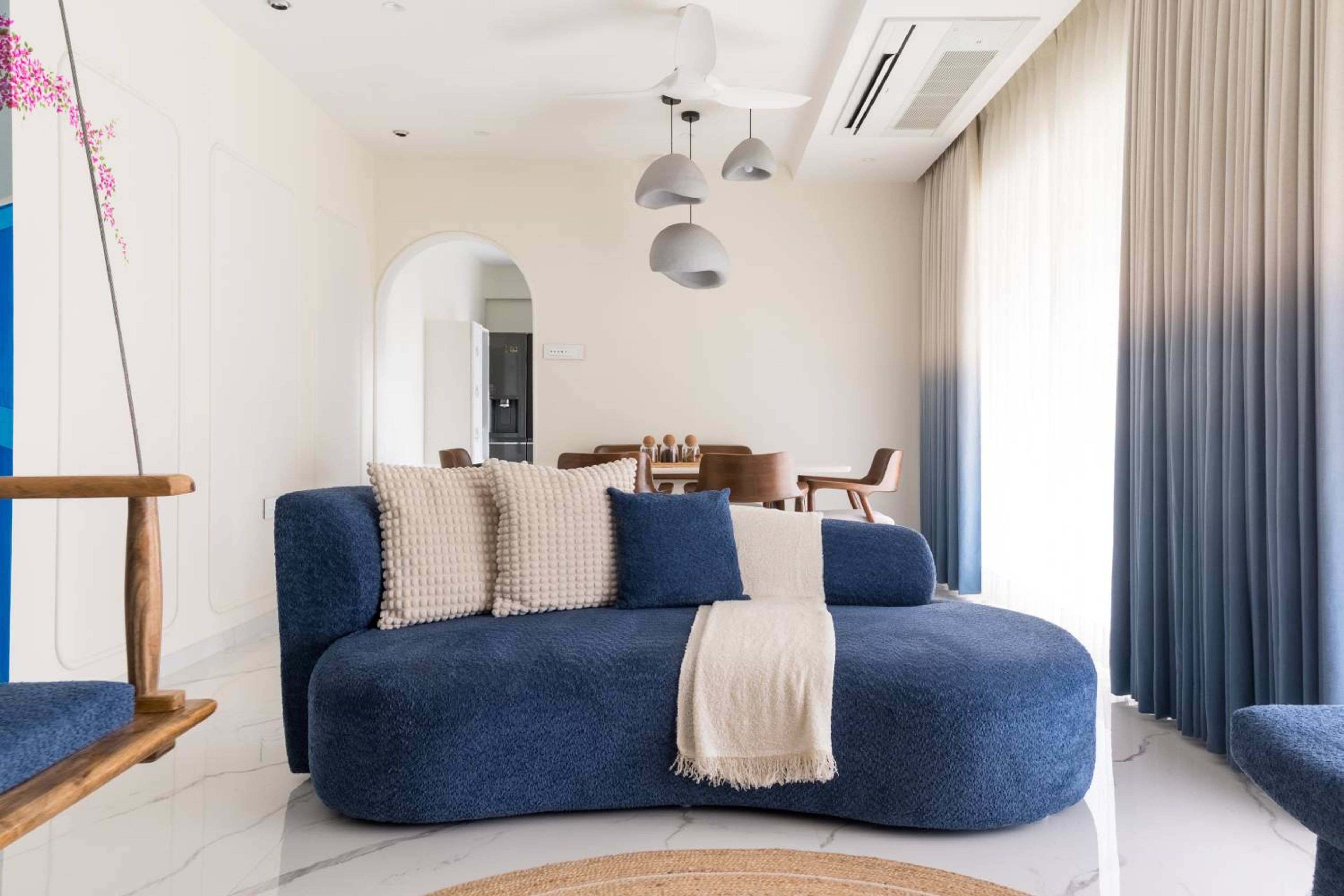 Modern Living Room Design With Dark Blue Curved Sofa, Ombre Curtains and Wooden Detaling