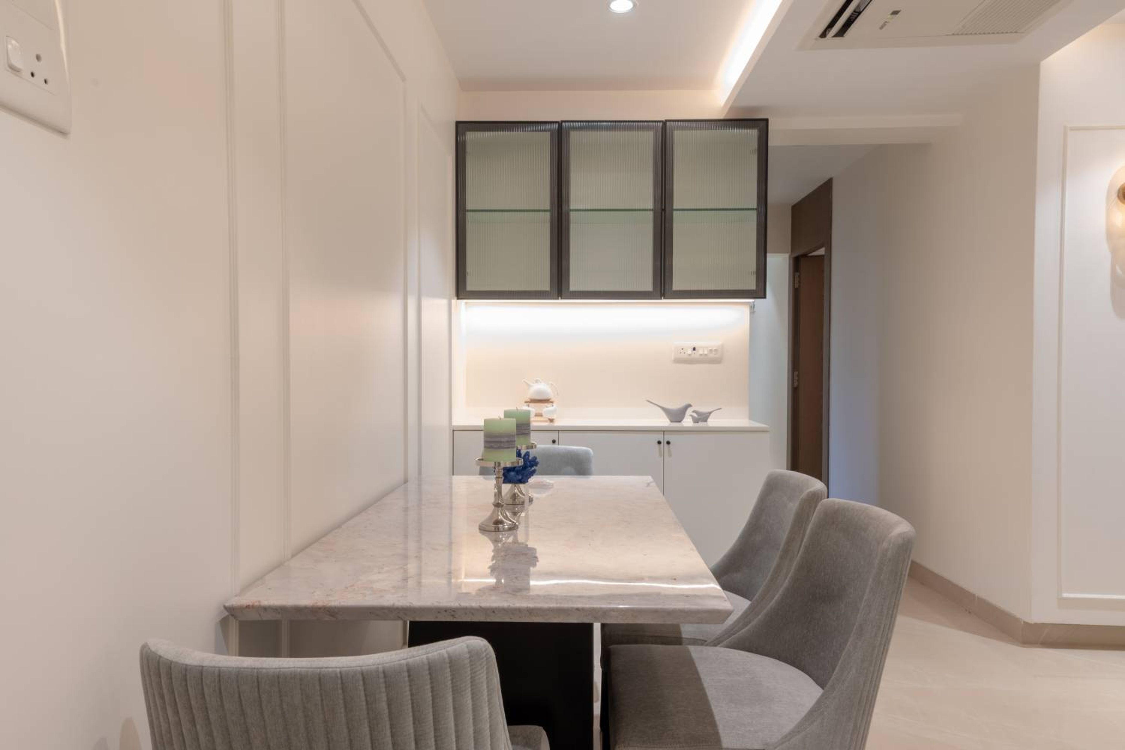 4-Seater Dining Room Design with Grey Chairs and Crockery Unit