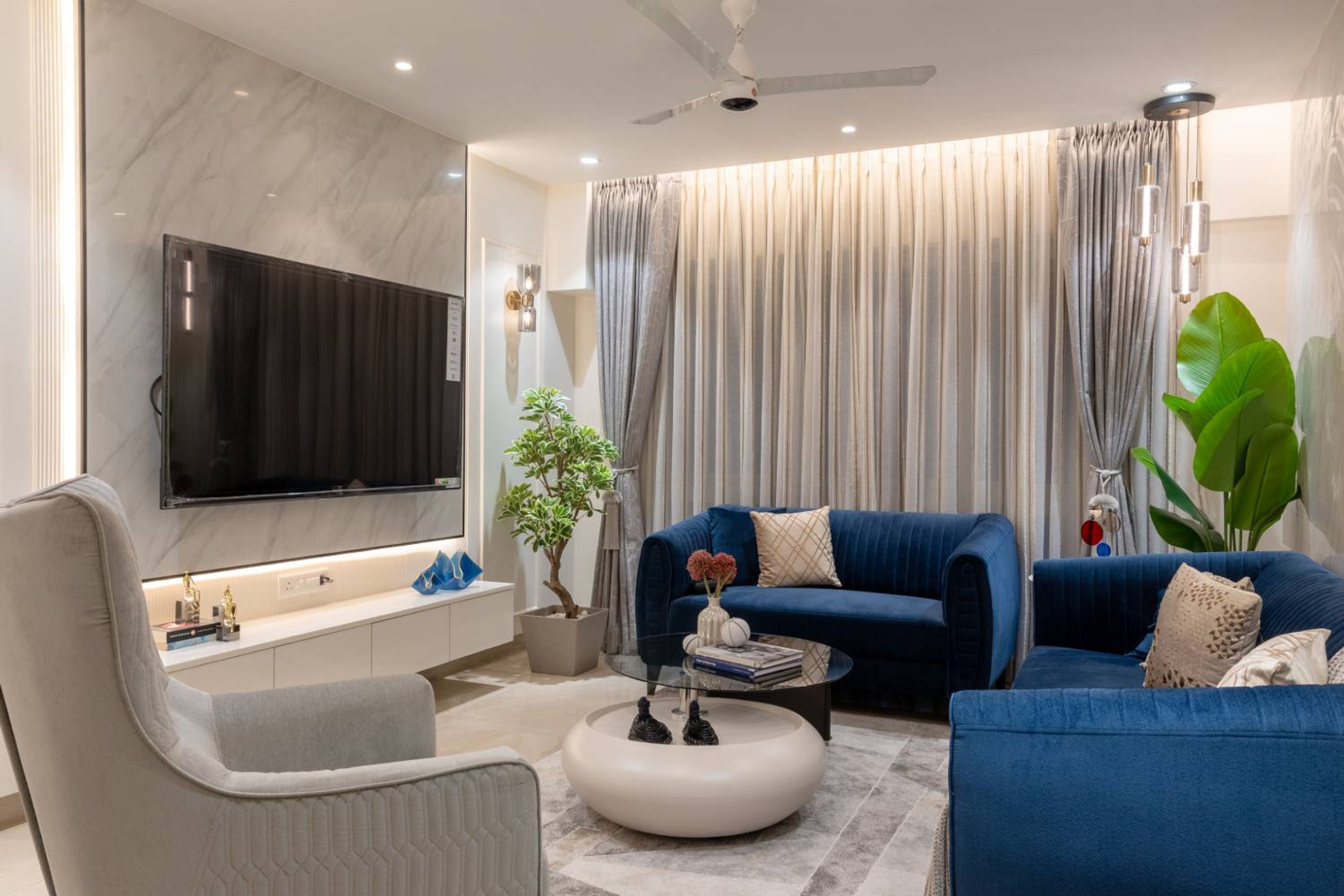 Blue Modern Living Room Design With Floating TV and Marble Accents