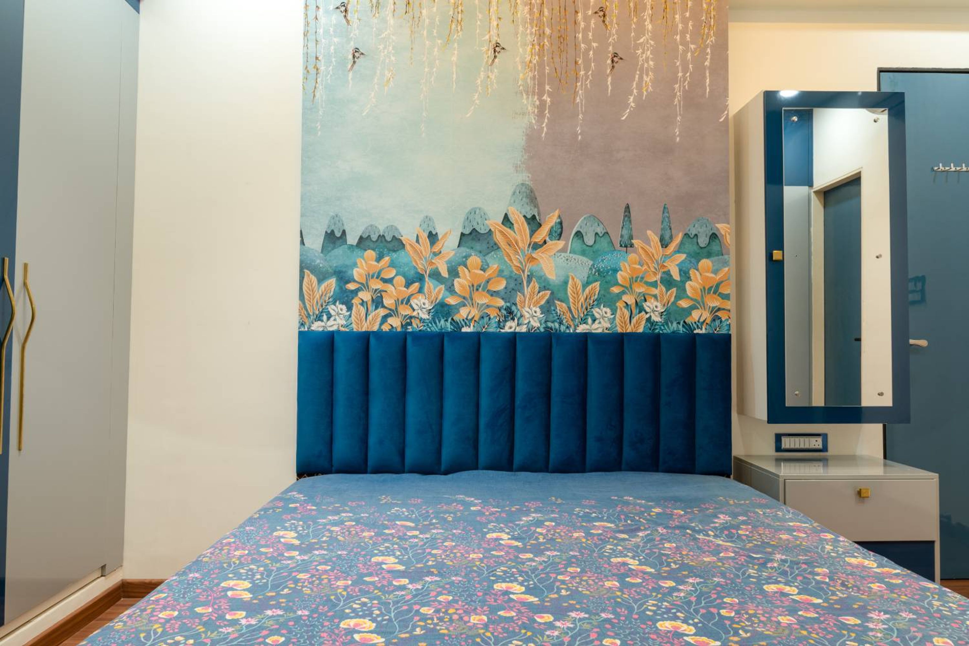 Bedroom design with floral patterned headboard wall and dressing unit