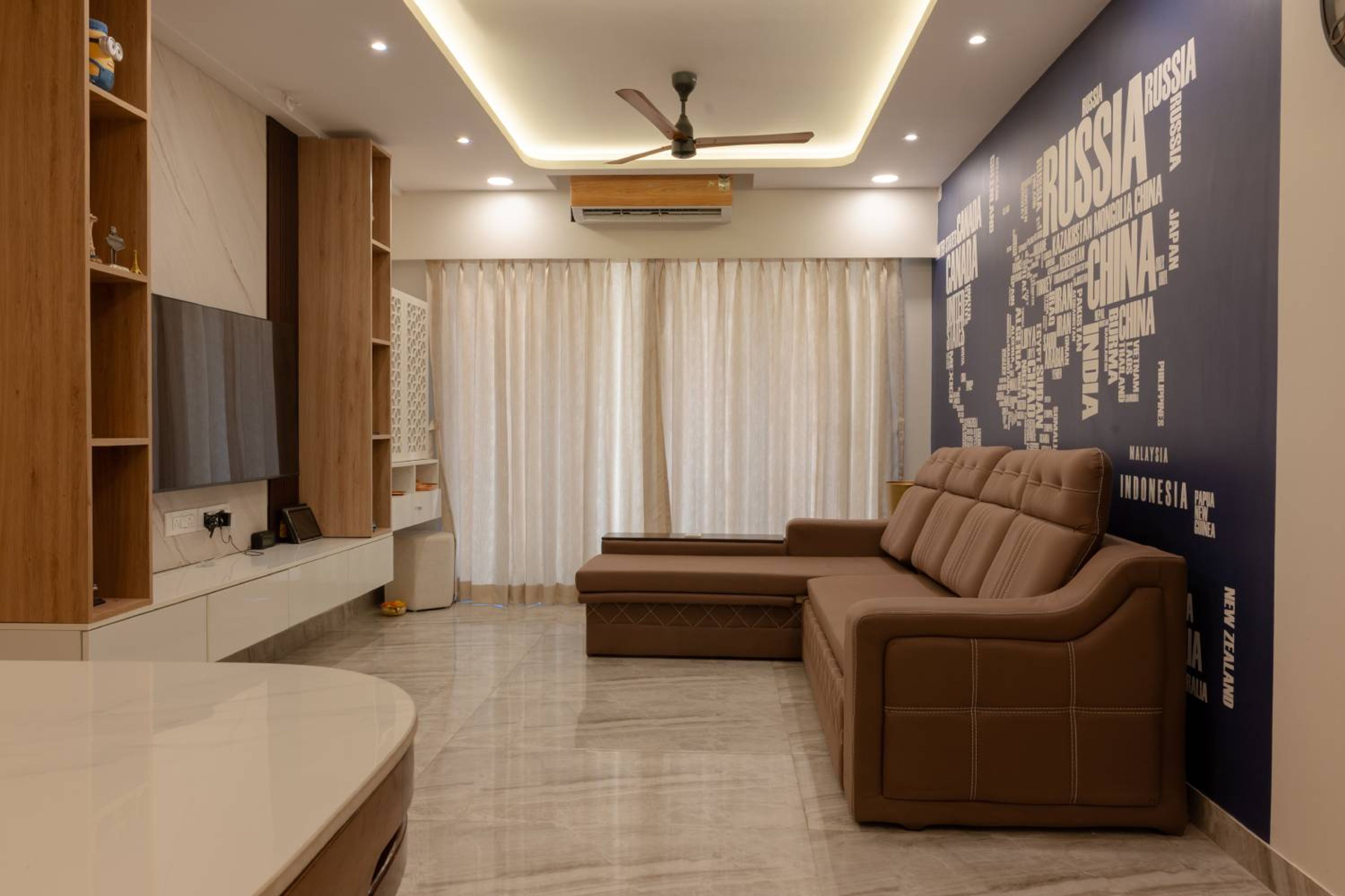 Living Room Design with Brown L-Shaped Sofa and World Map Wallpaper
