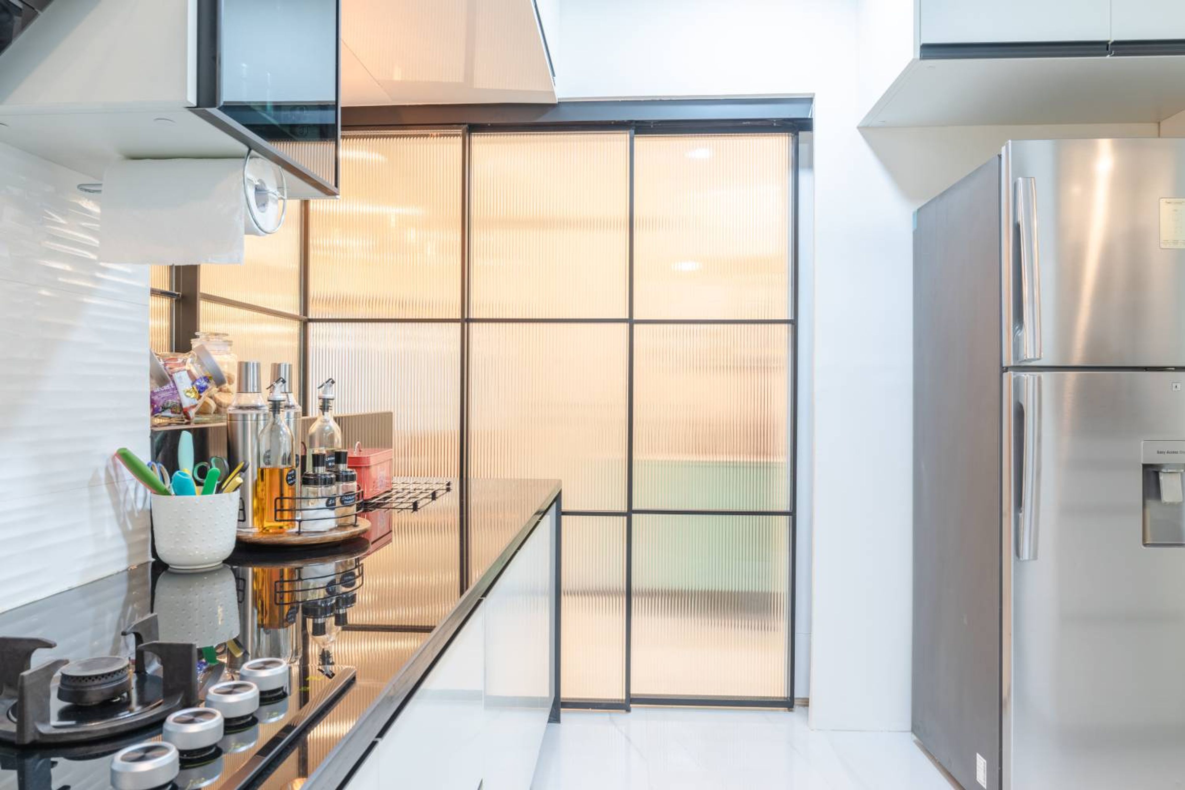 L-Shaped Kitchen Design with Granite Countertop and Frosted Glass Shutter Partition