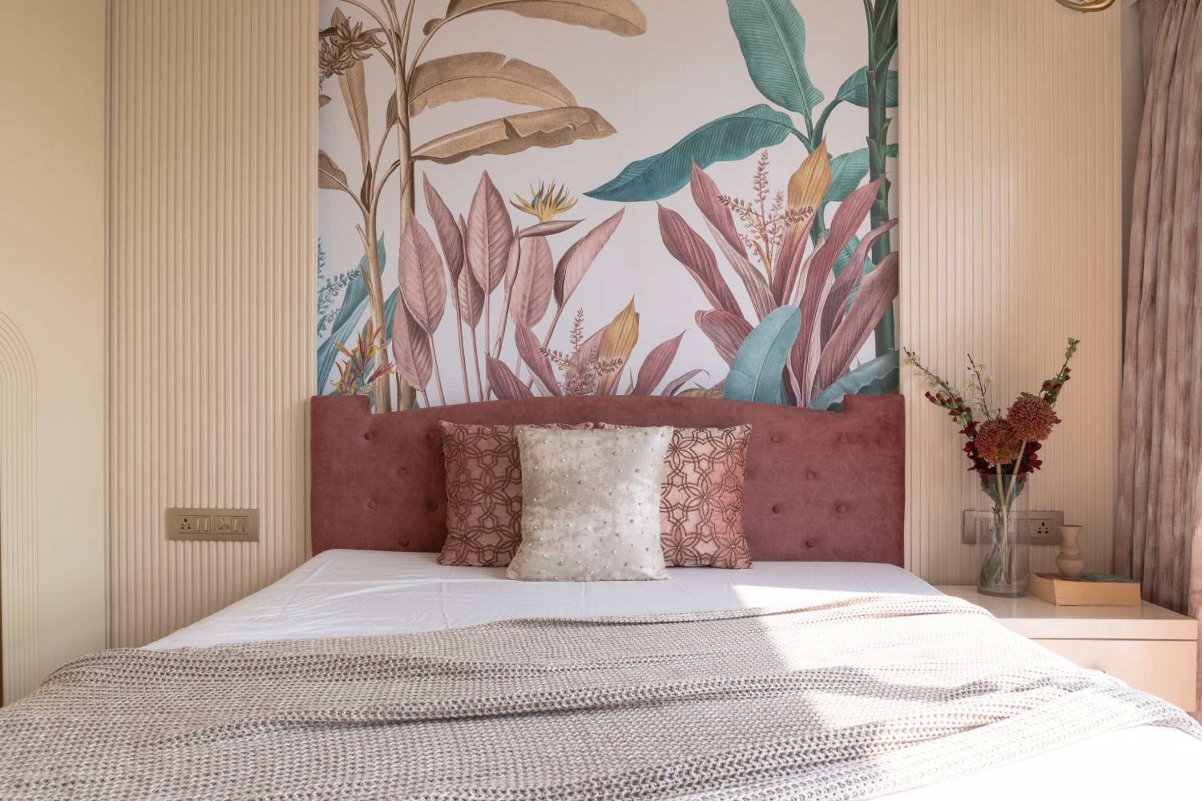 Bedroom Design with Botanical Wall Mural, Tufted Pink Headboard, and Textured Accent Paneling