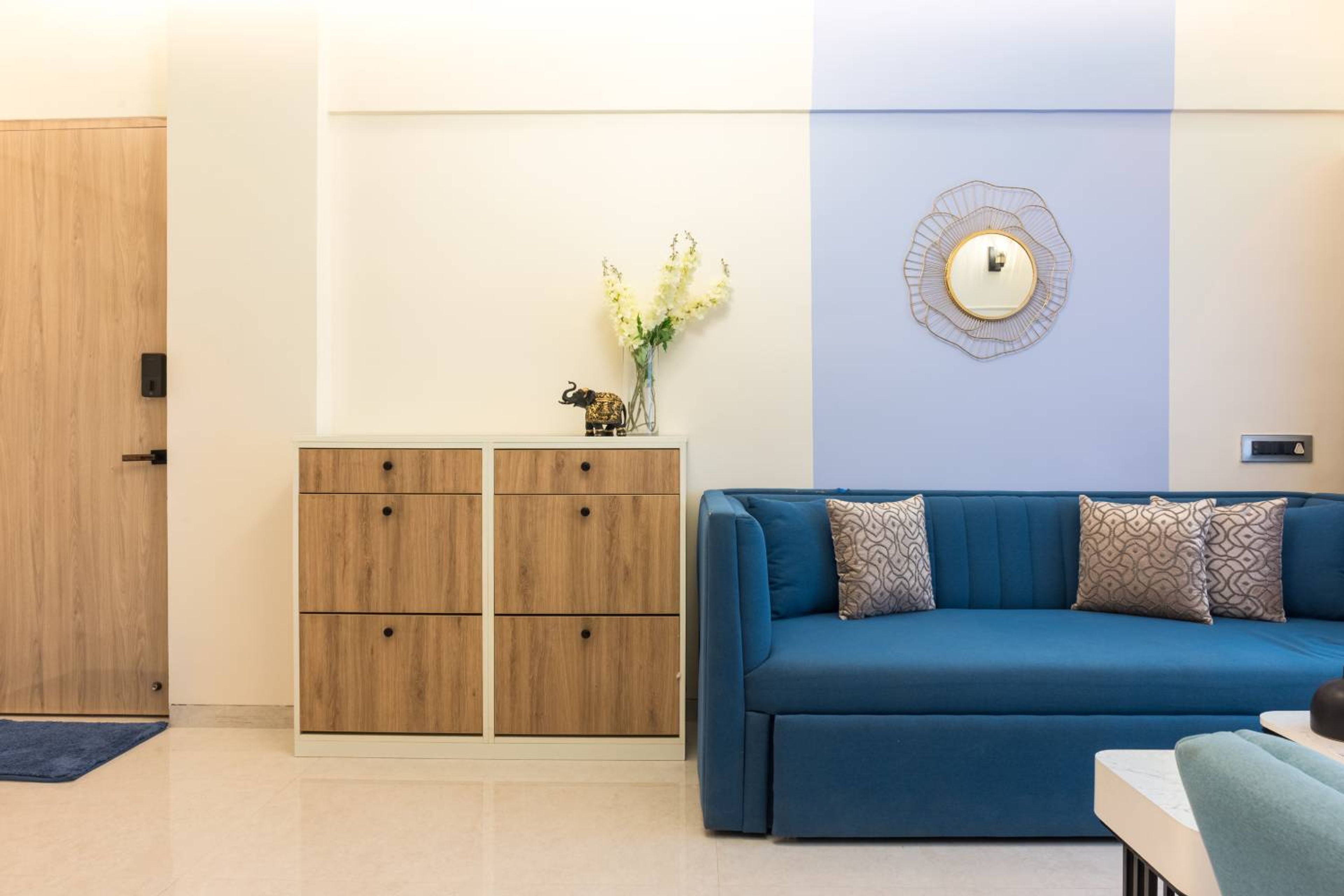 Living Room Wall Design with Wooden Shoe Cabinet and Blue Sofa