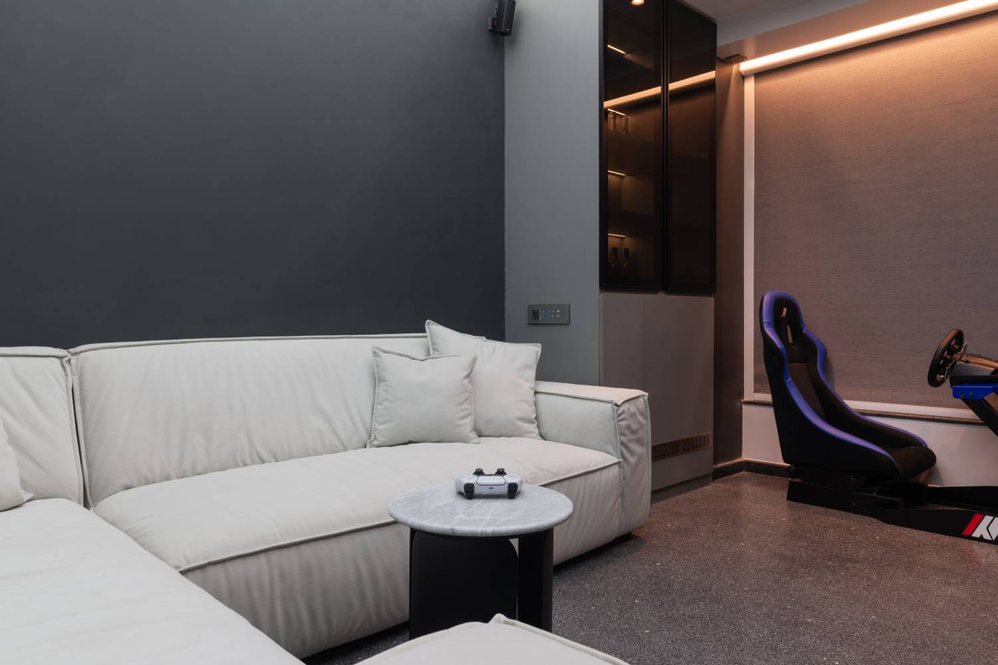 Gaming room with white L-shaped sofa