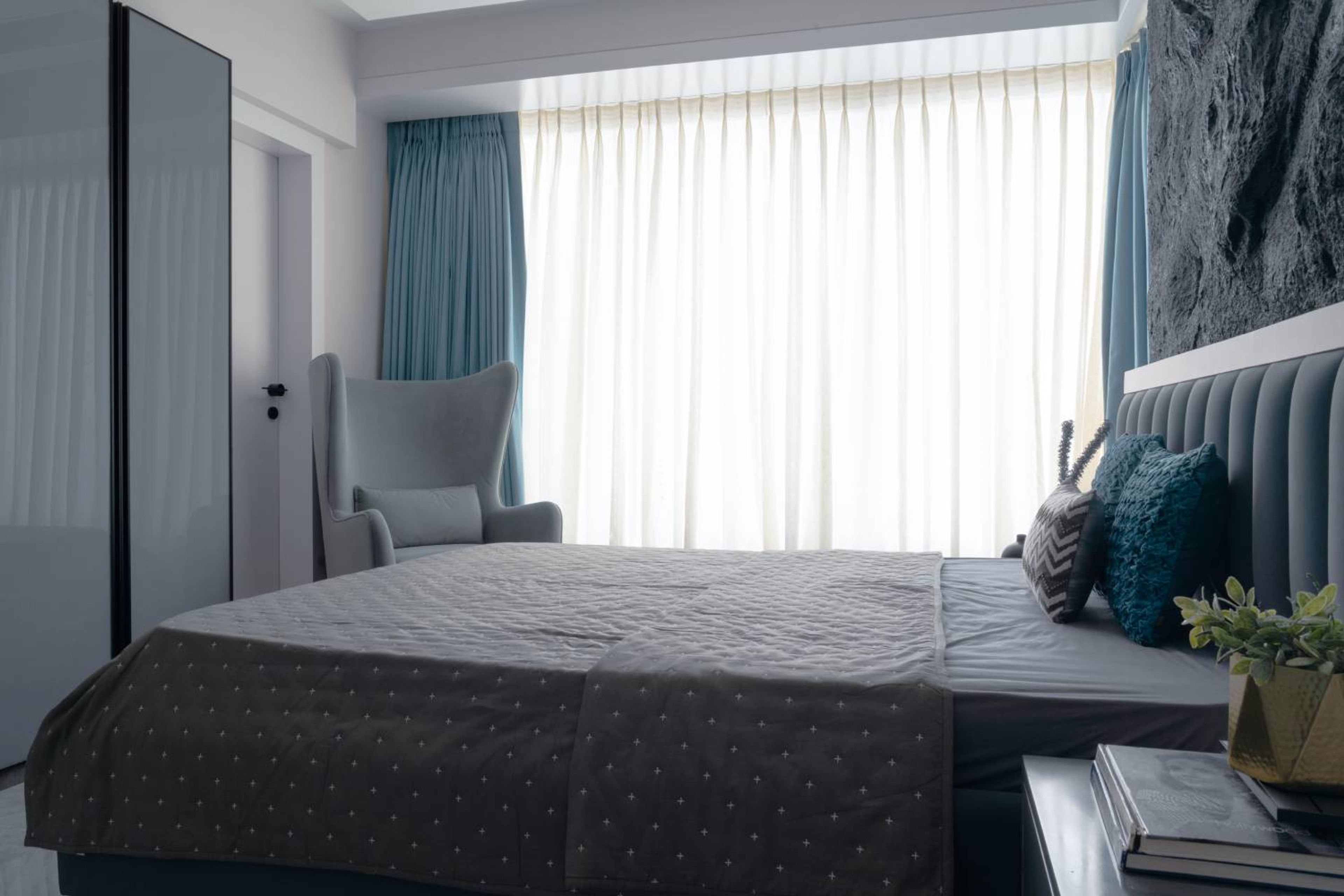 Modern Guest Bedroom Design with Accent Chair and Stone Accent Wall