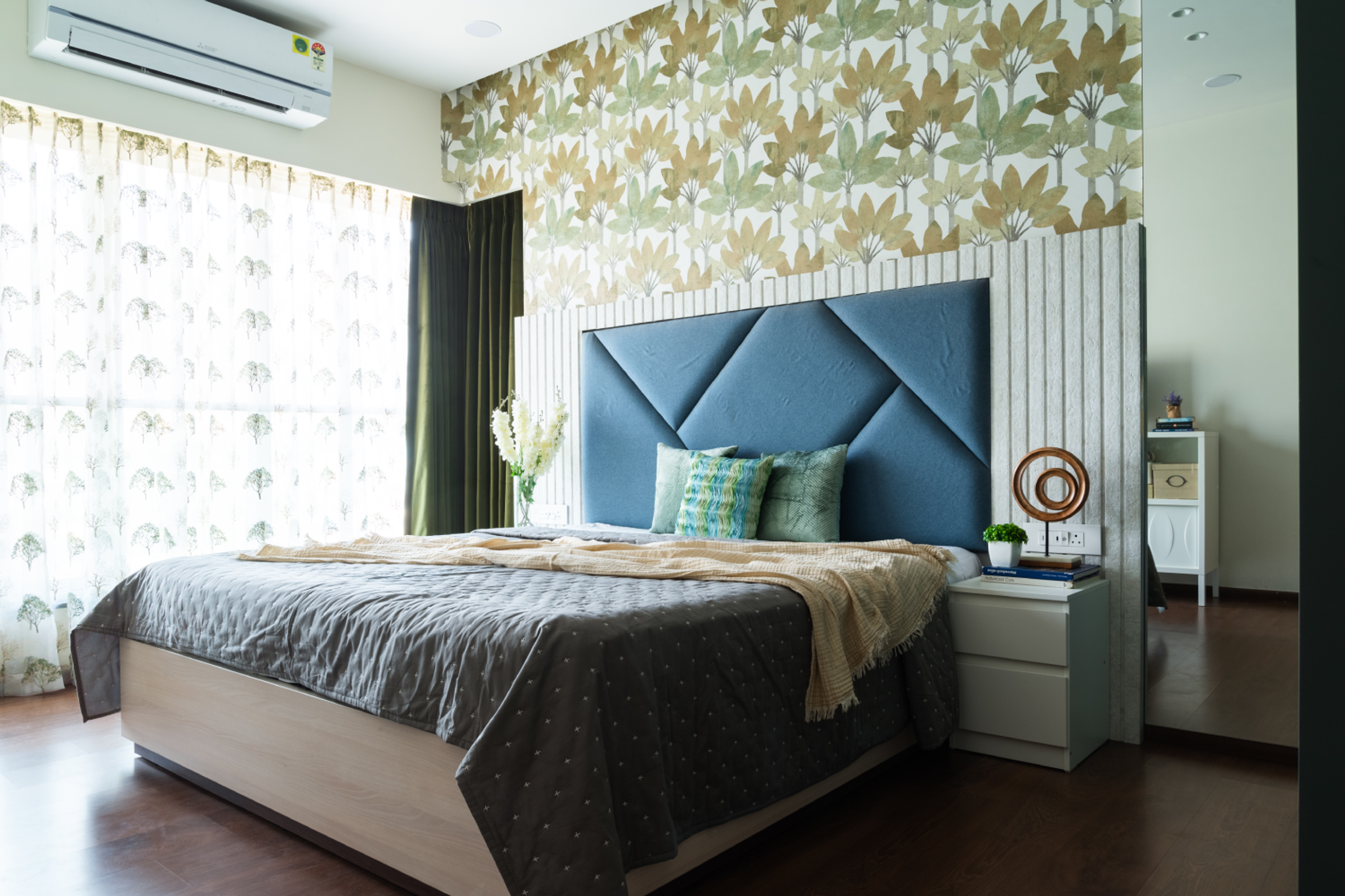 Bedroom design with floral pattern wall and cushioned headboard