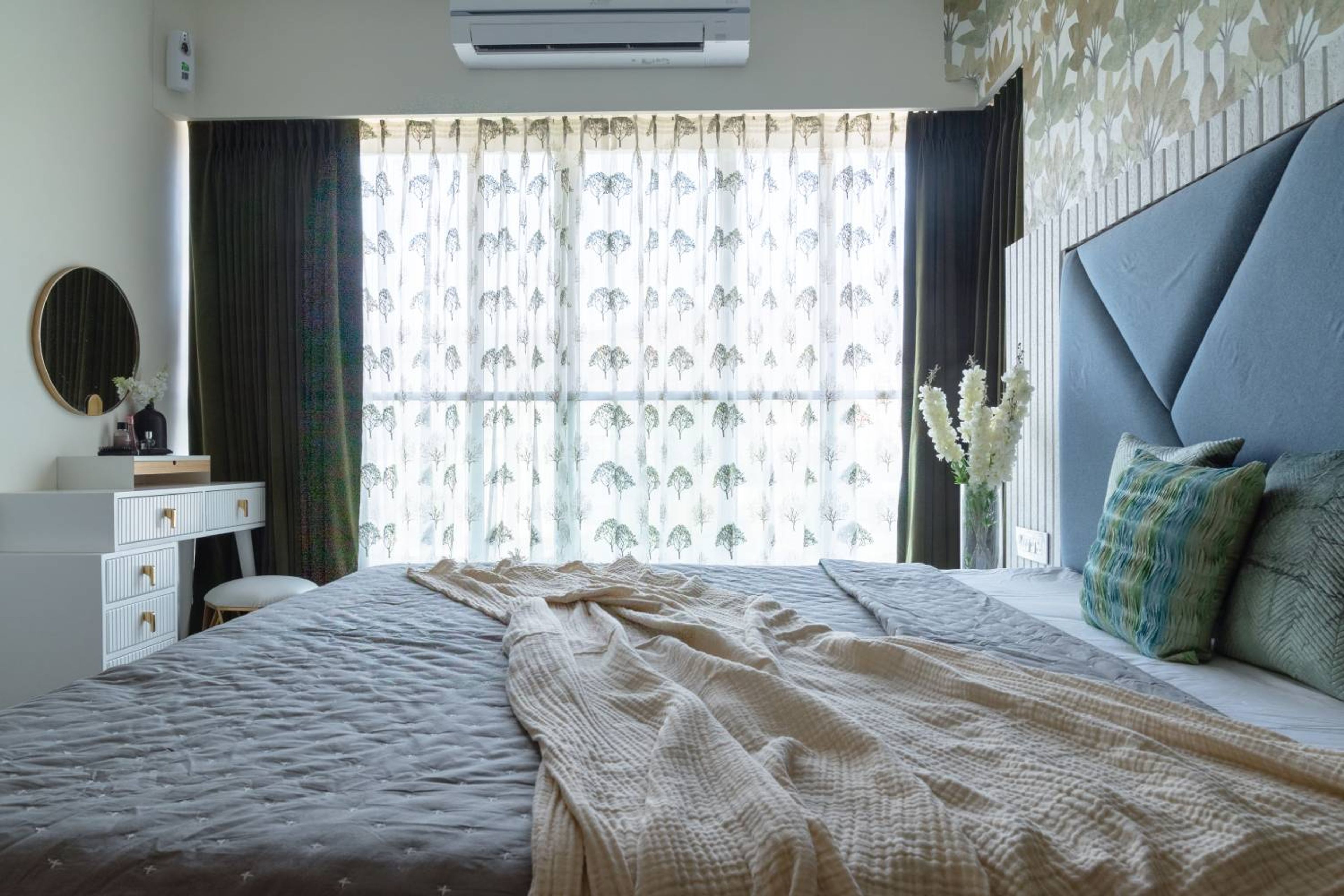 Bedroom design with floral pattern wall and white vanity with round mirror