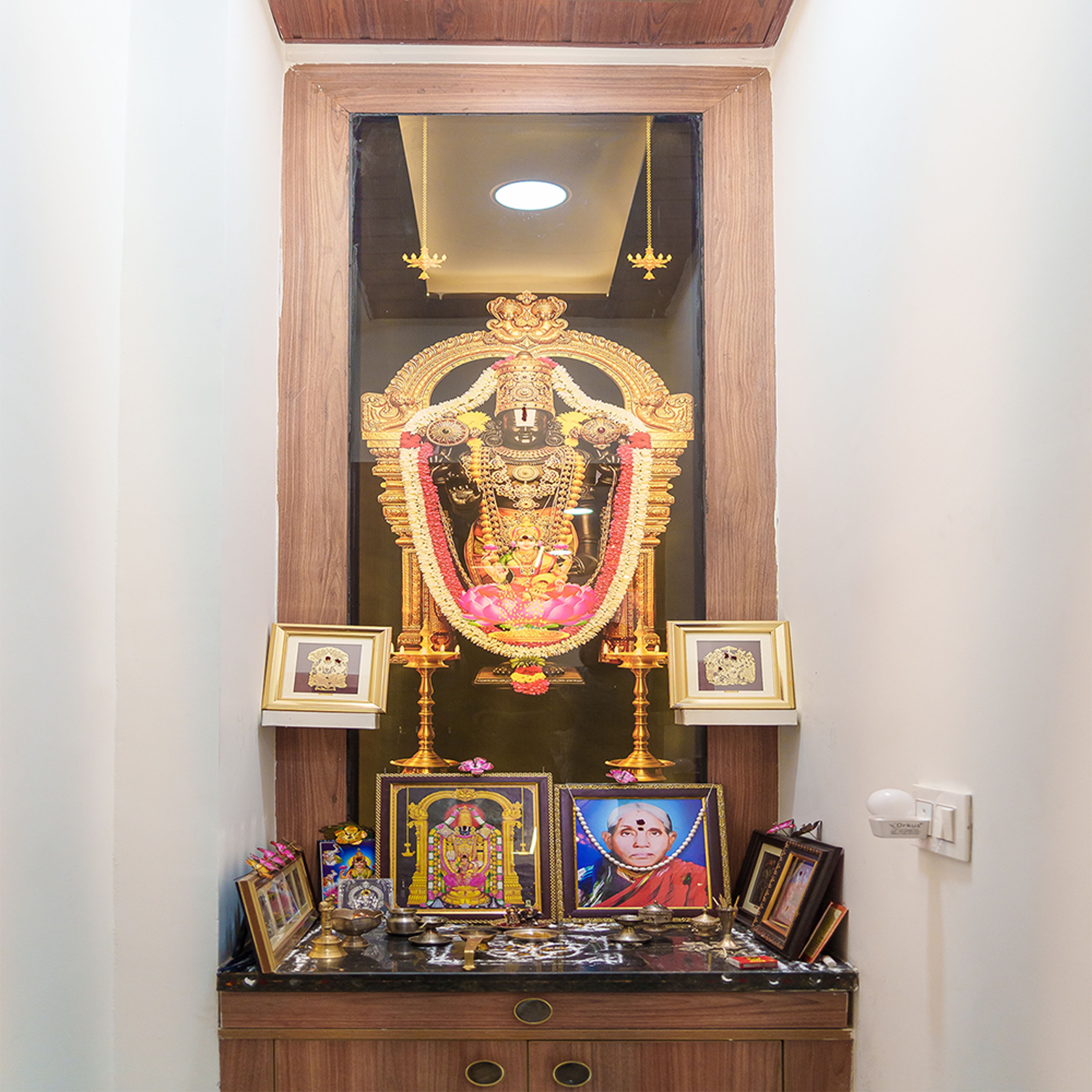 Indian Traditional Pooja Room Design with Glass-Framed Idol and Drawers