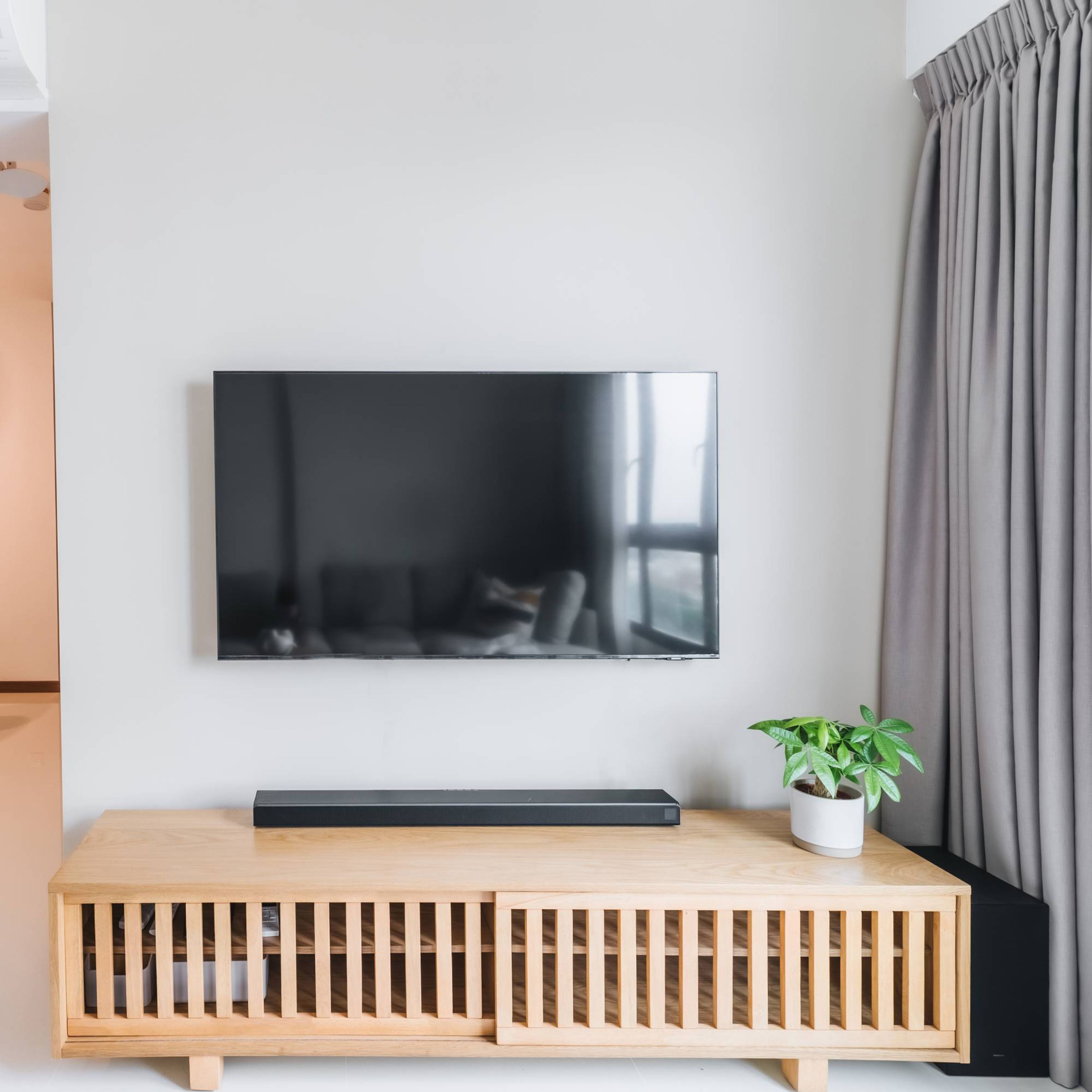TV Unit With A Light Wooden Finish And Closed Storage - Livspace