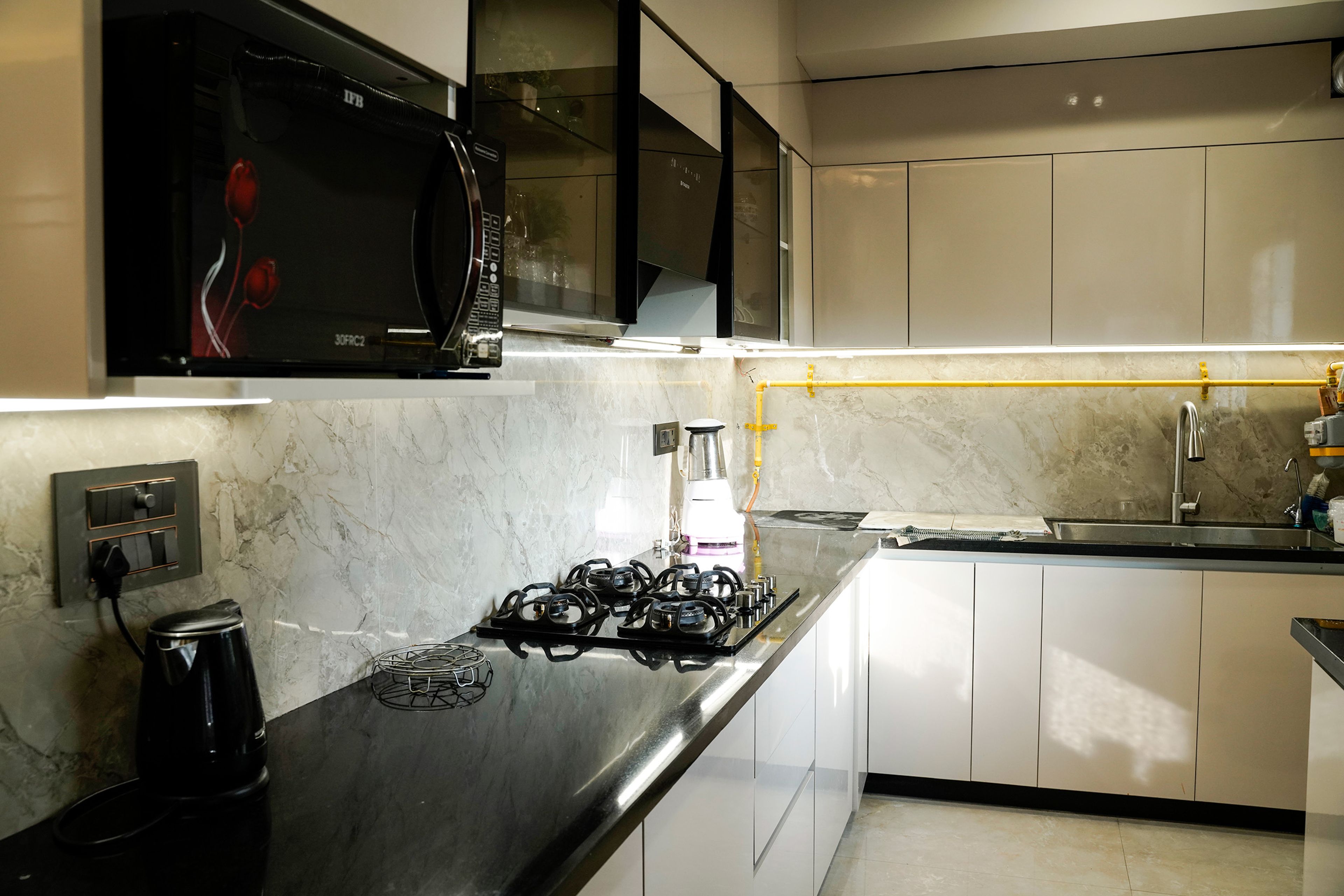 L-Shaped Kitchen Design with Marble Backsplash and Glass Cabinets