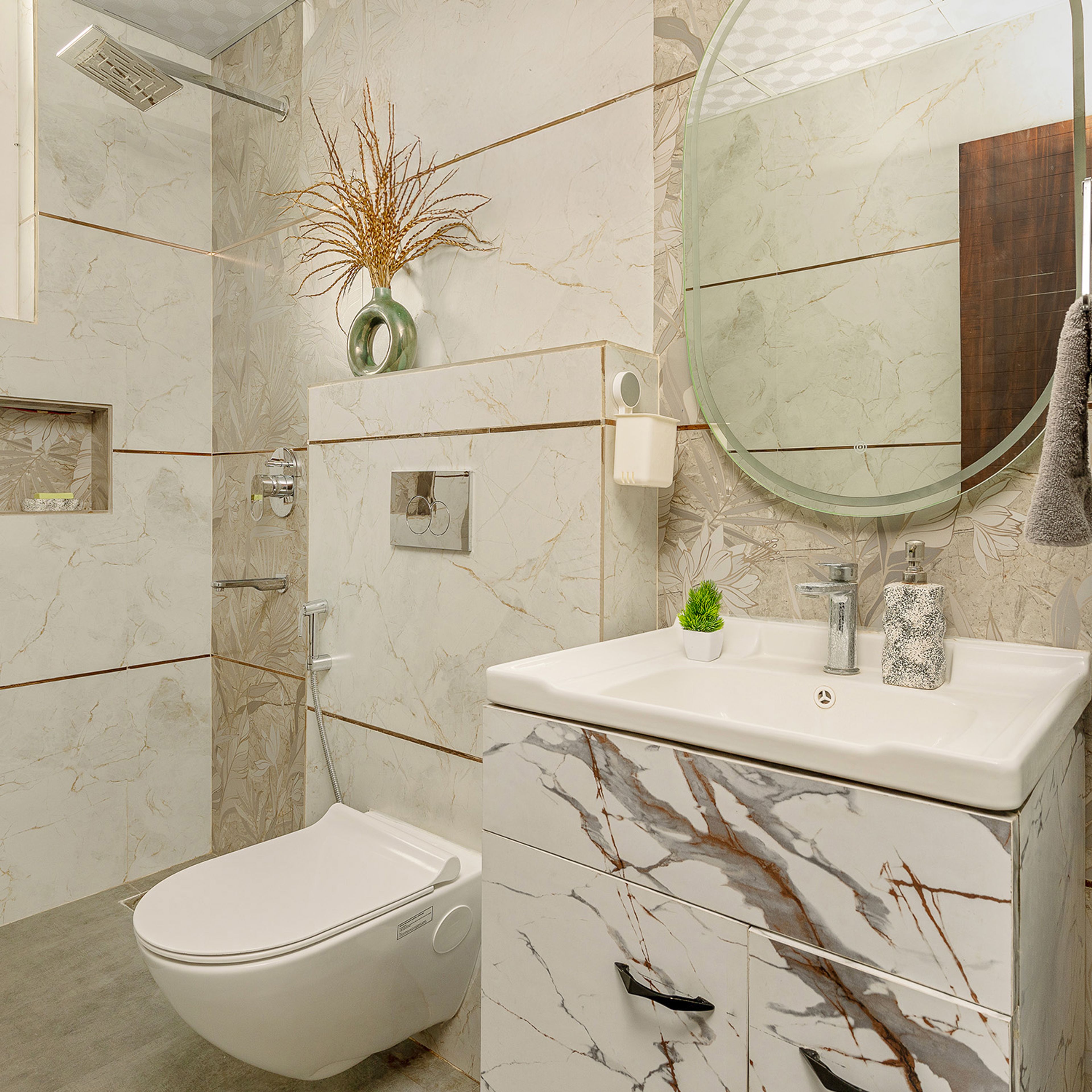 Bathroom with floral tiles, marble vanity, round mirror, and decorative greenery