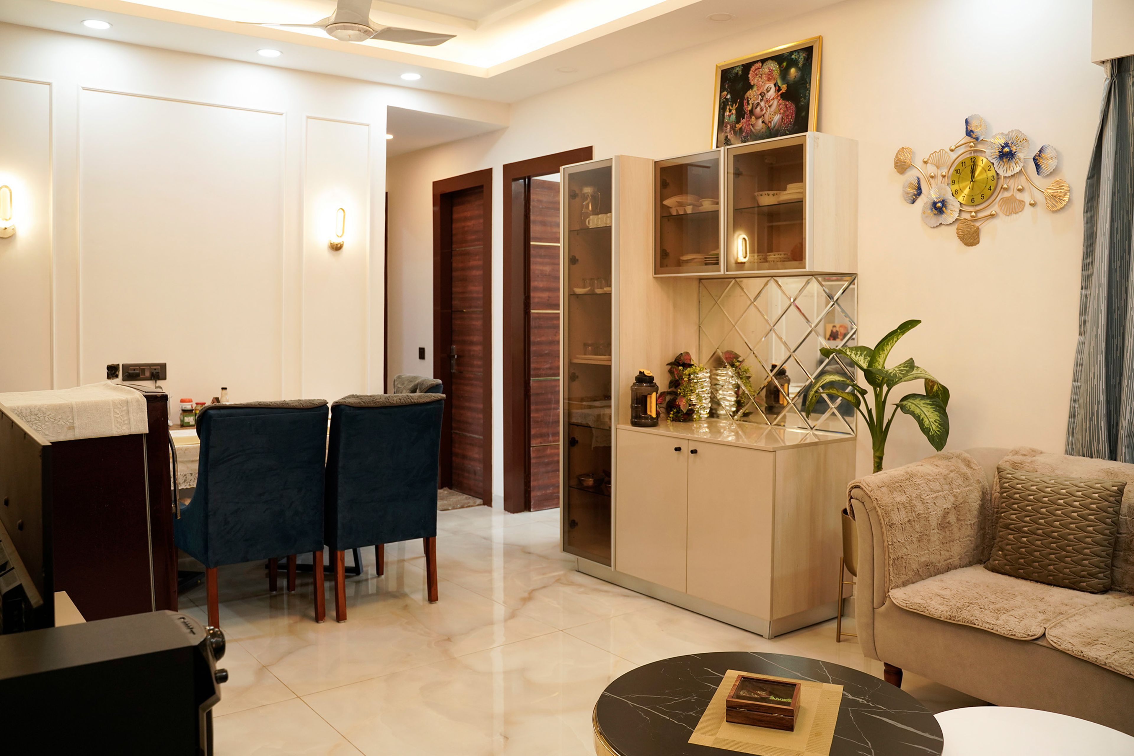 Dining area with cozy chairs, wall sconces, and open shelving for decor display