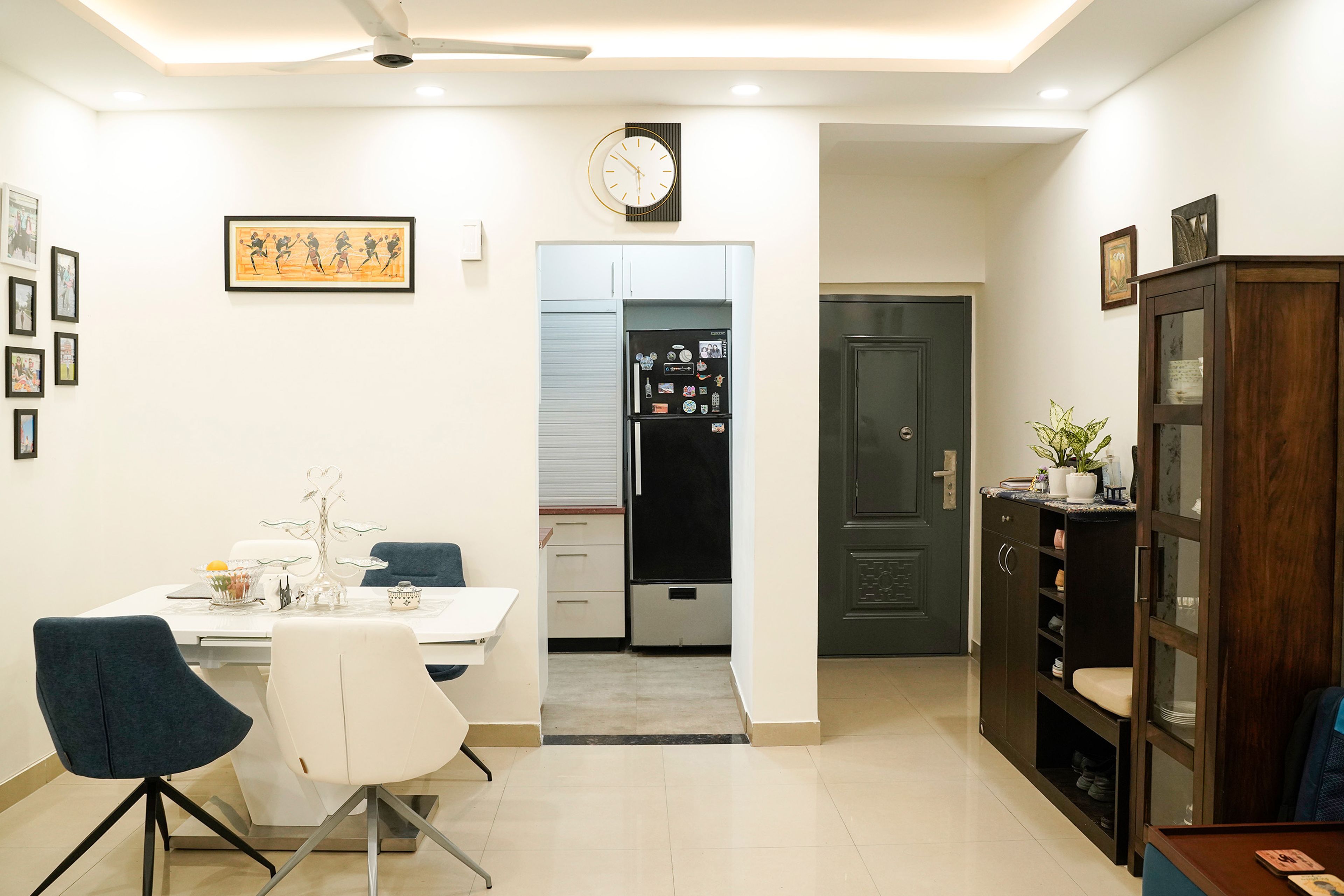 Open dining area with white furniture, glass cabinet, and modern lighting for a spacious feel