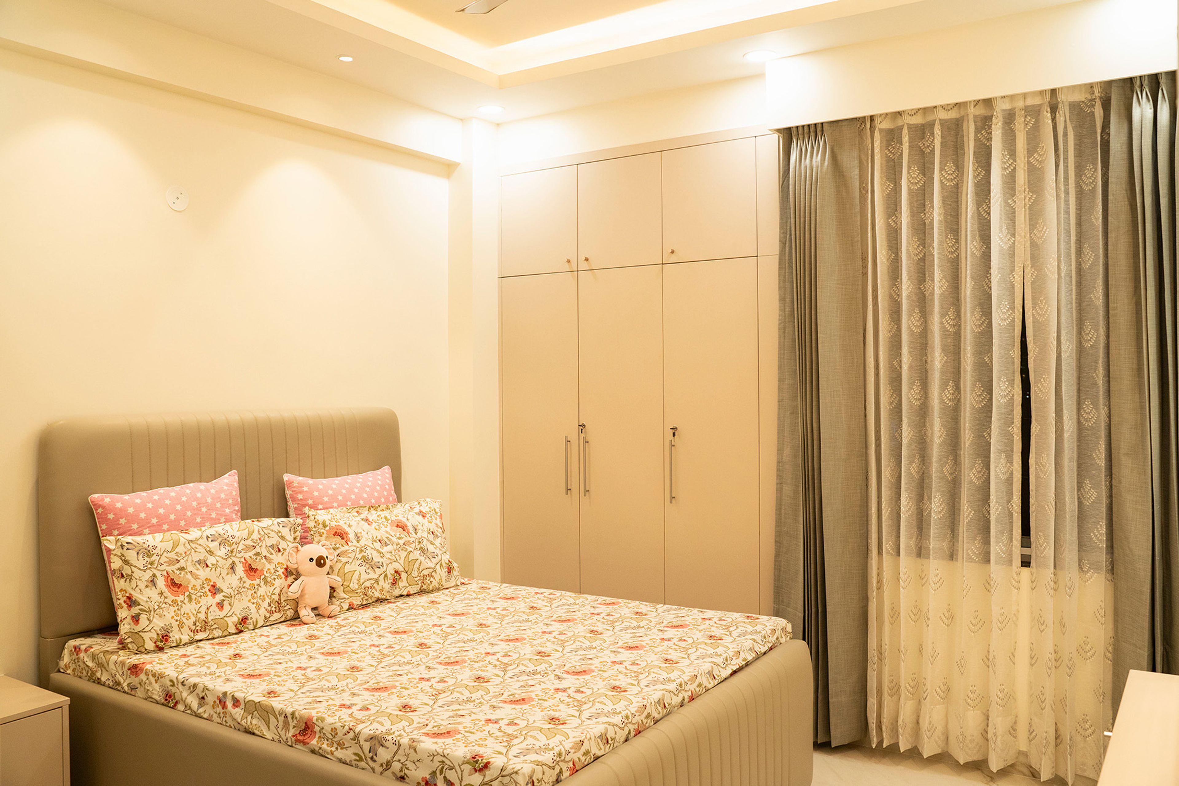 Modern Guest Bedroom Design with Glossy Beige Wardrobe and Wall-Mounted TV Unit