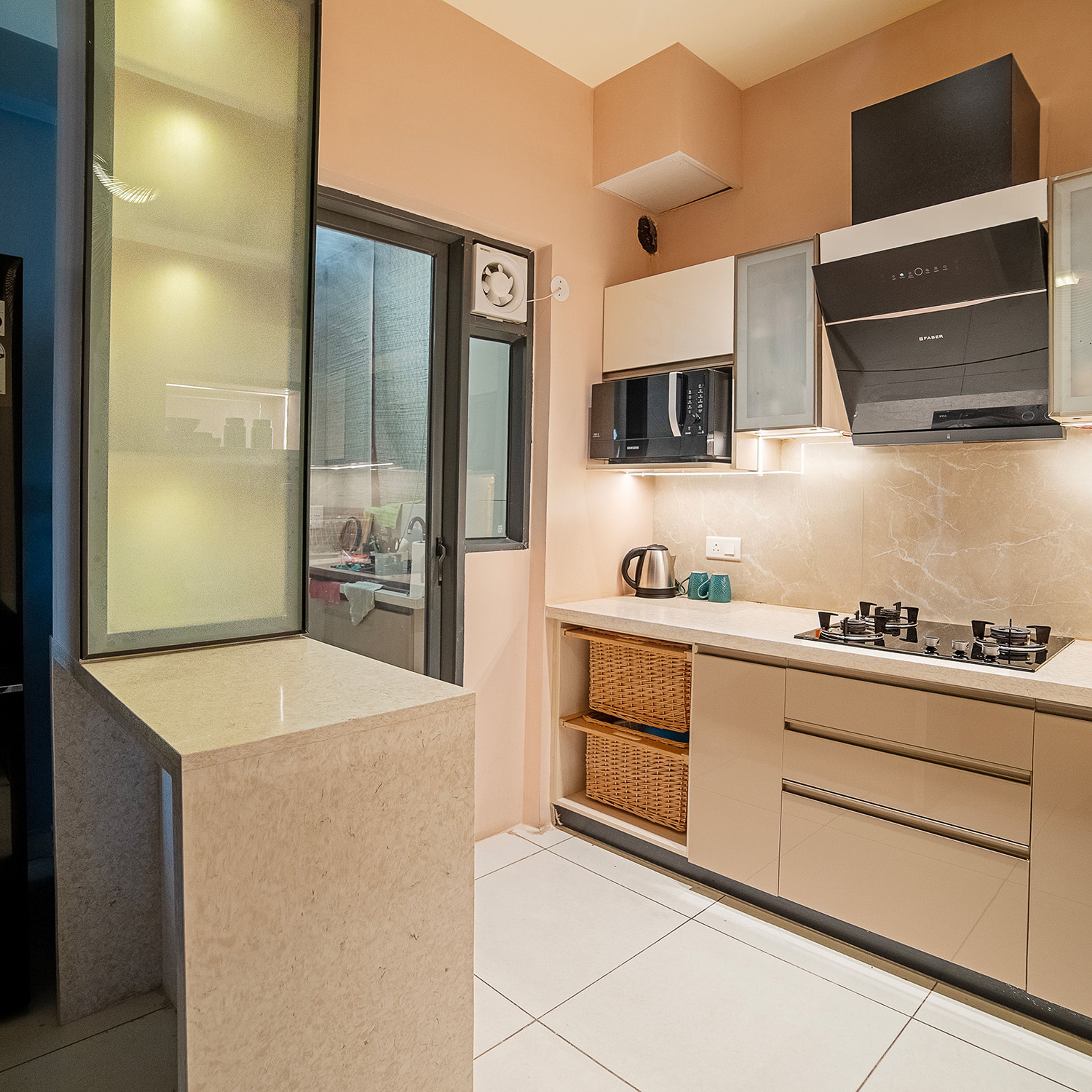 L-Shaped beige kitchen with wicker basket storage and overhead frosted glass cabinets