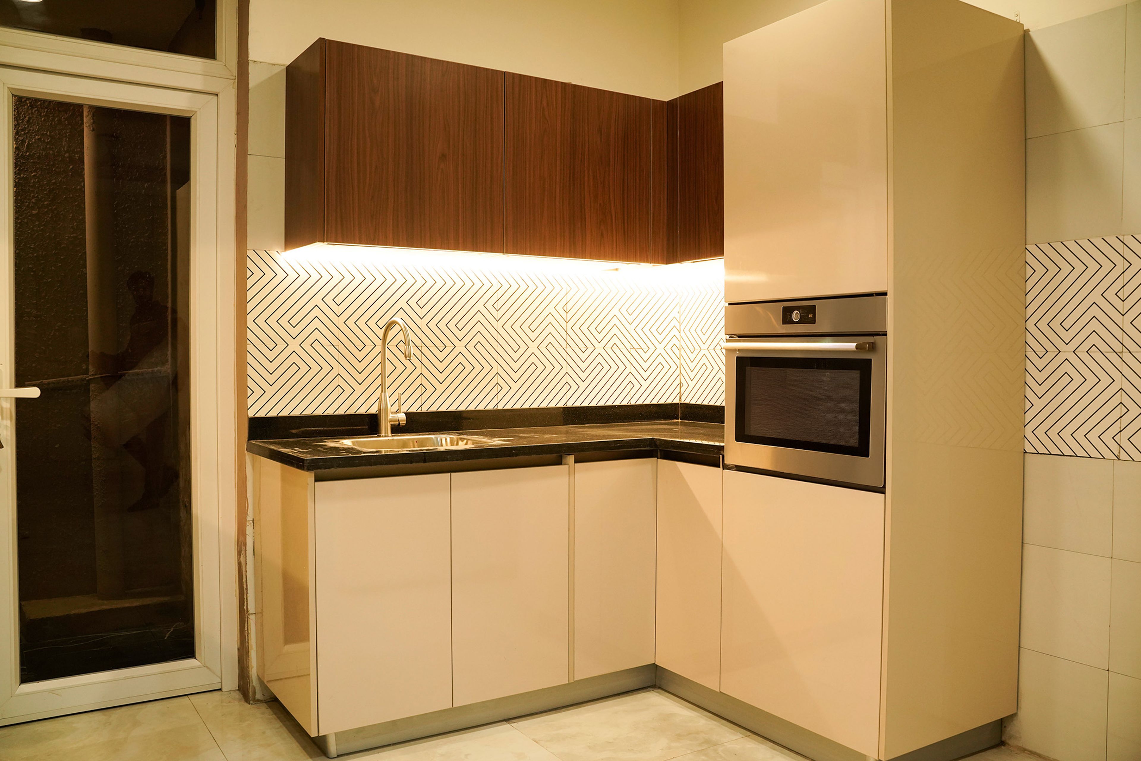L-Shaped kitchen with patterned backsplash, under-cabinet LED lighting and lower drawers
