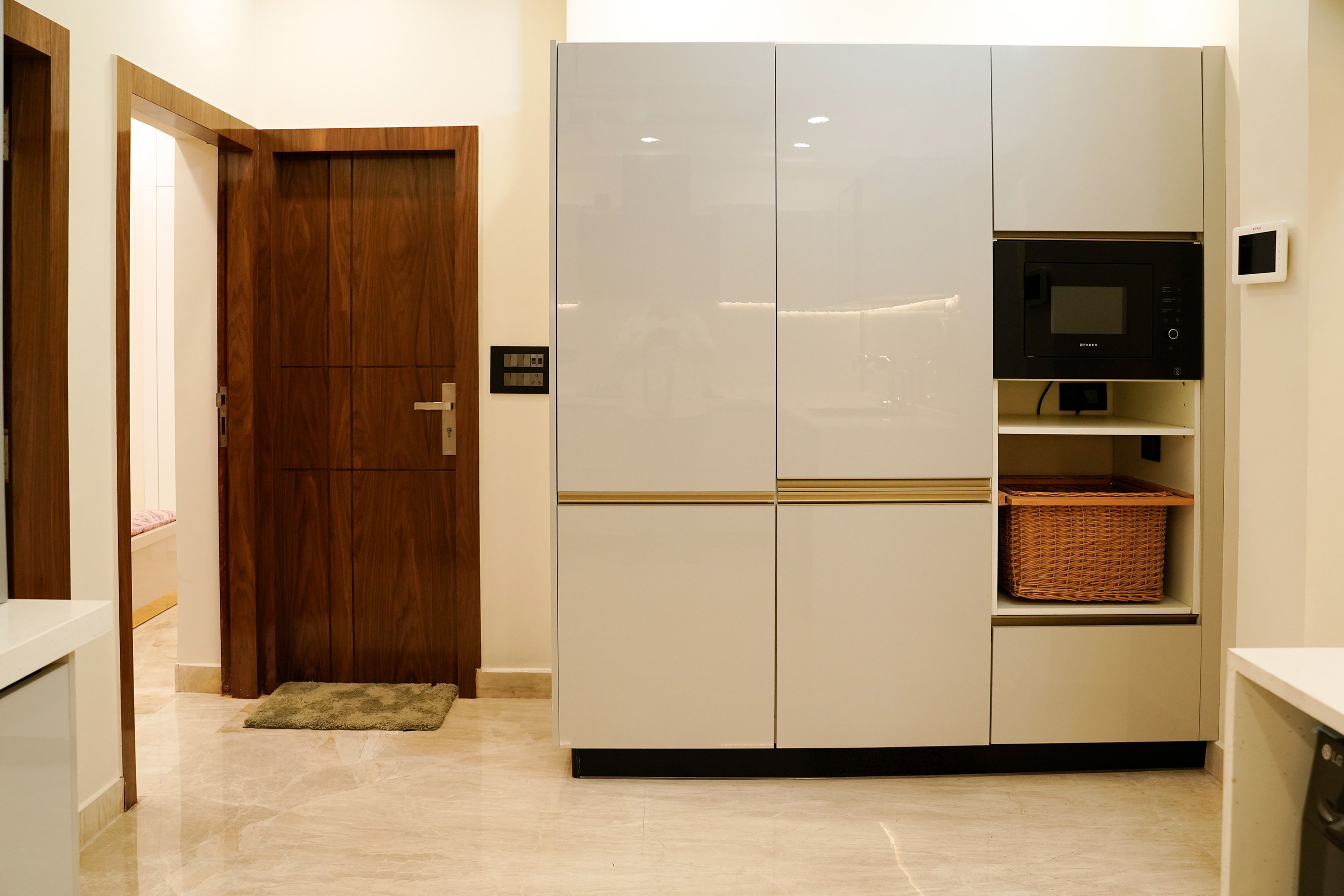 Glossy beige and white U-Shaped kitchen with roller shutter storage and black chimney centerpiece