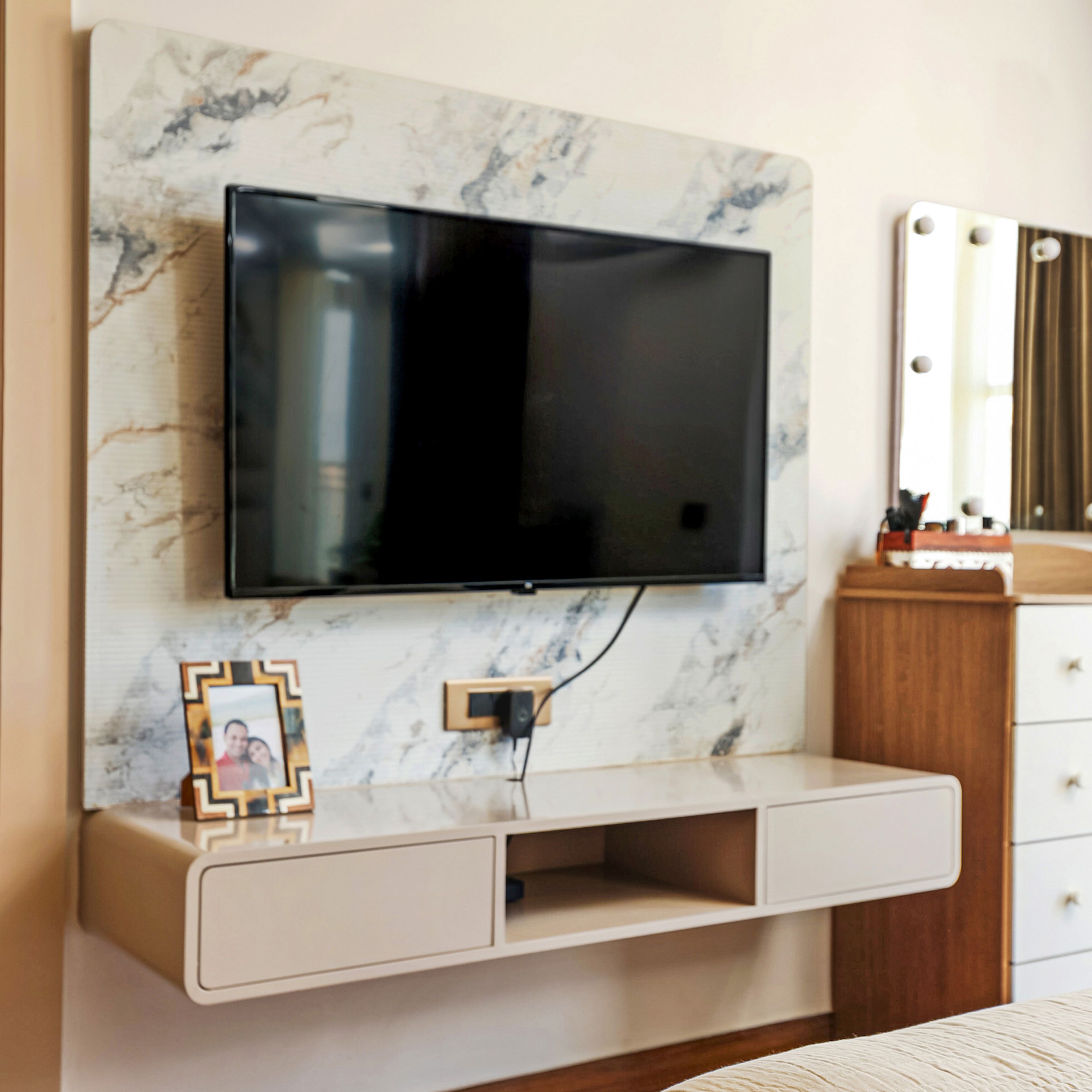 Marble-effect floating TV unit with open compartments in a minimal modern bedroom