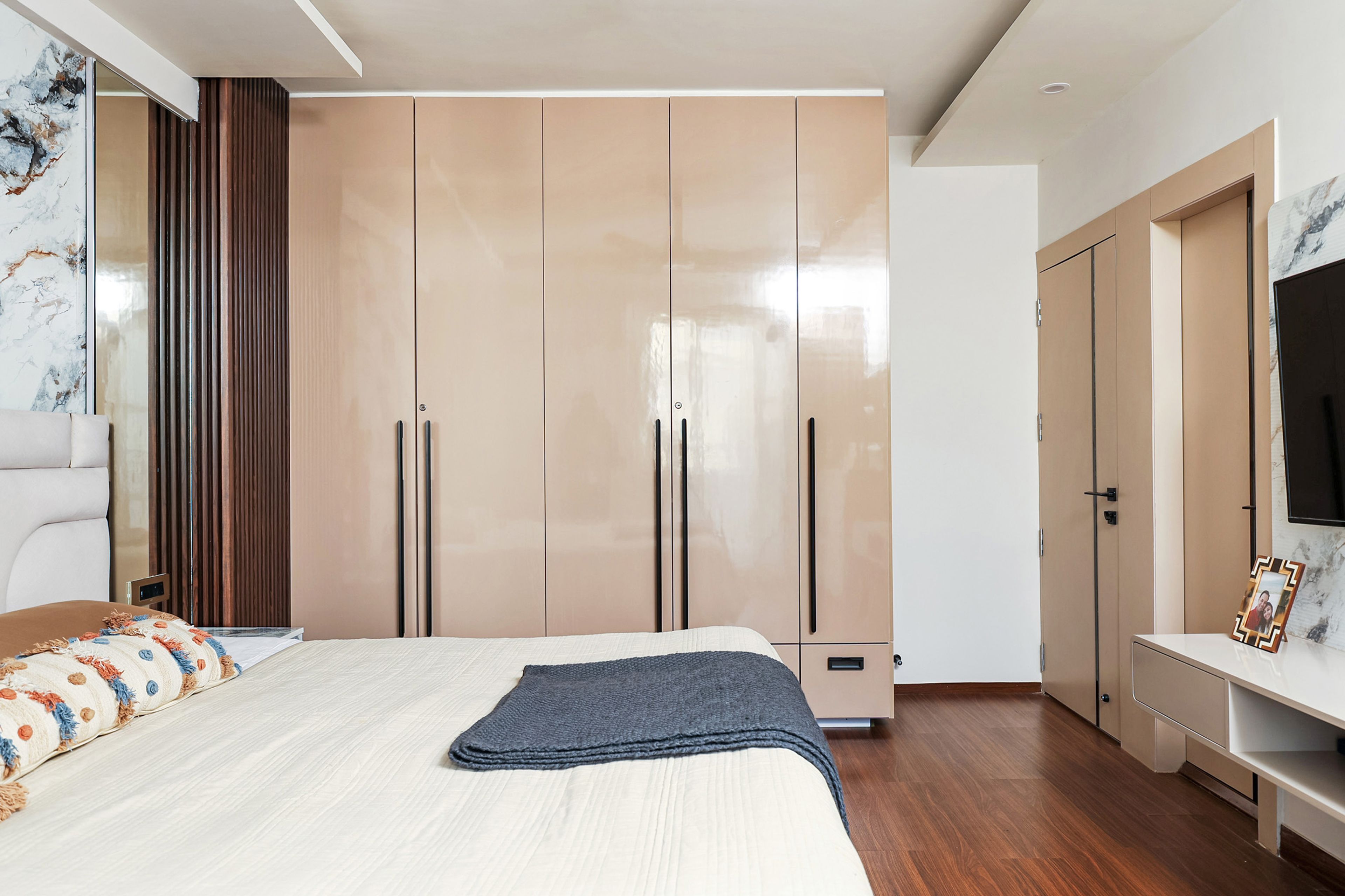 Master Bedroom Design with Full-Height Glossy Wardrobes and Marble Effect Accent Wall