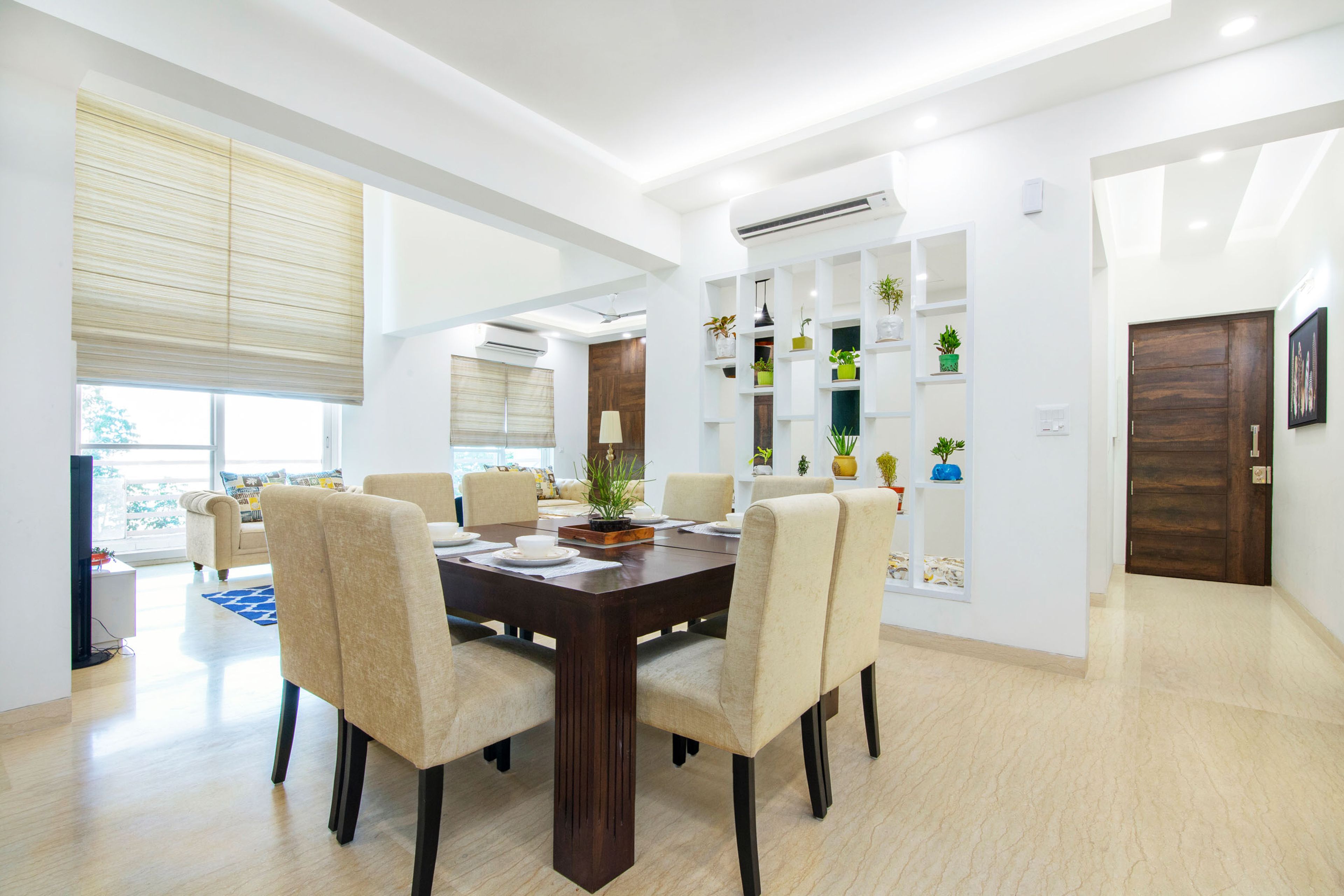 8-Seater Dining Room With Cream Upholstered Chairs And A White Partition - Livspace
